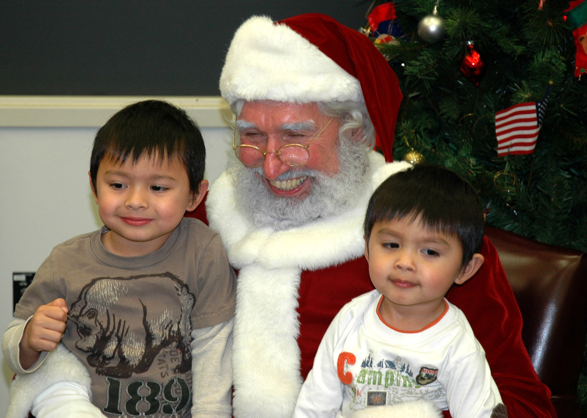 JOINT BASE LEWIS-MCCHORD, Wash.- left to right, Ryan, 4, and Tyler, 2, sons of Tech. Sgt. Gene Garcia, loadmaster with the 728th Airlift Squadron, got a chance to get their pictures taken with Santa during the squadron's holiday party, Dec. 4 in the 446th Operations Group Auditorium. The 446th Airlift Wing held several holiday parties this weekend to herald in the holiday season. (U.S. Air Force Photo/Staff Sgt. Nicole Celestine)