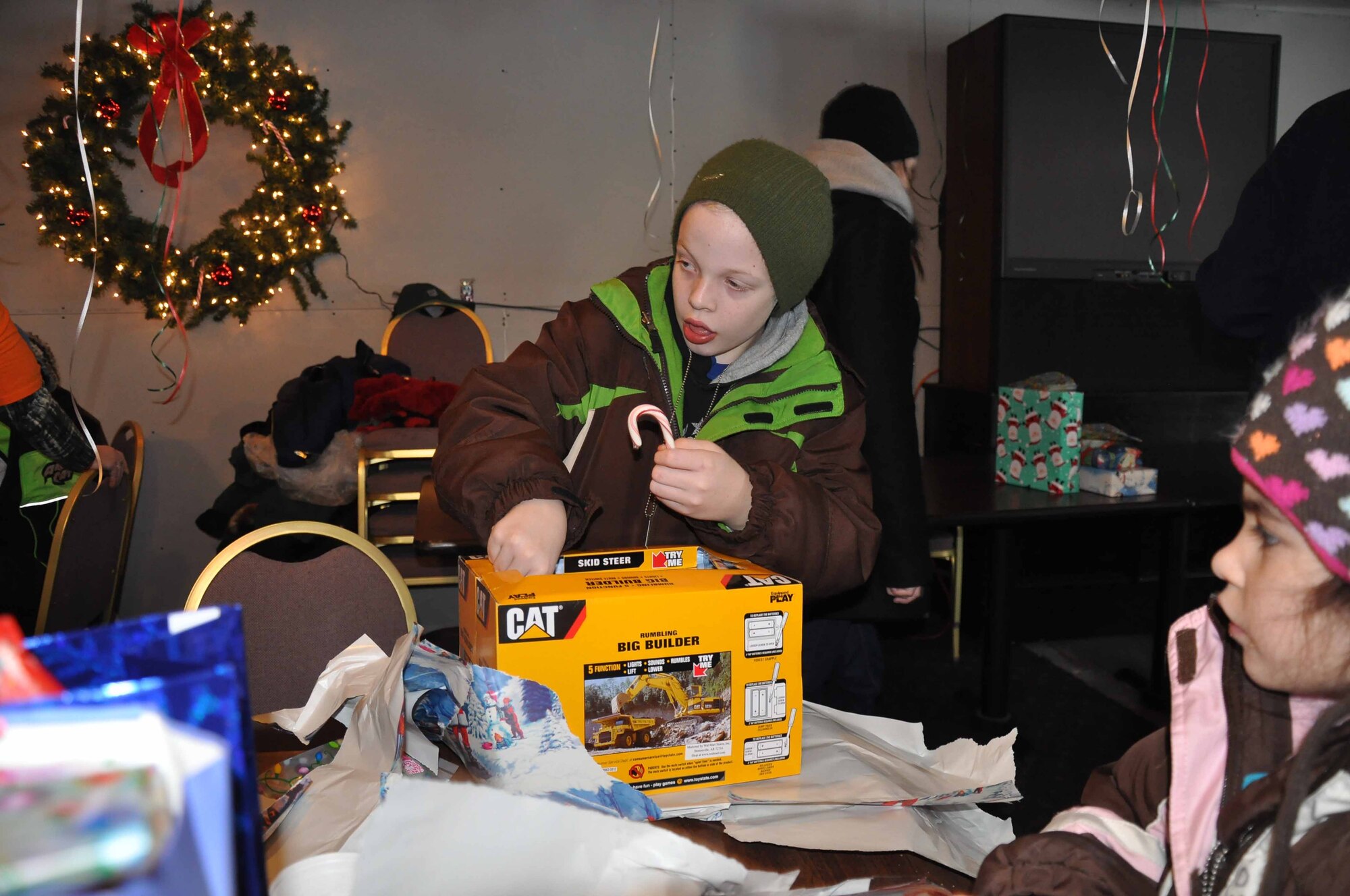 Special guests opens a present at the "North Pole"  during Operation Santa Flight 2010, the 934th Airlift Wing along with volunteers from AT&T and the Army National Guard make it possible for people with special needs to get a trip to meet with Santa (Air Force Photo/Tech. Sgt. Bob Sommer)
