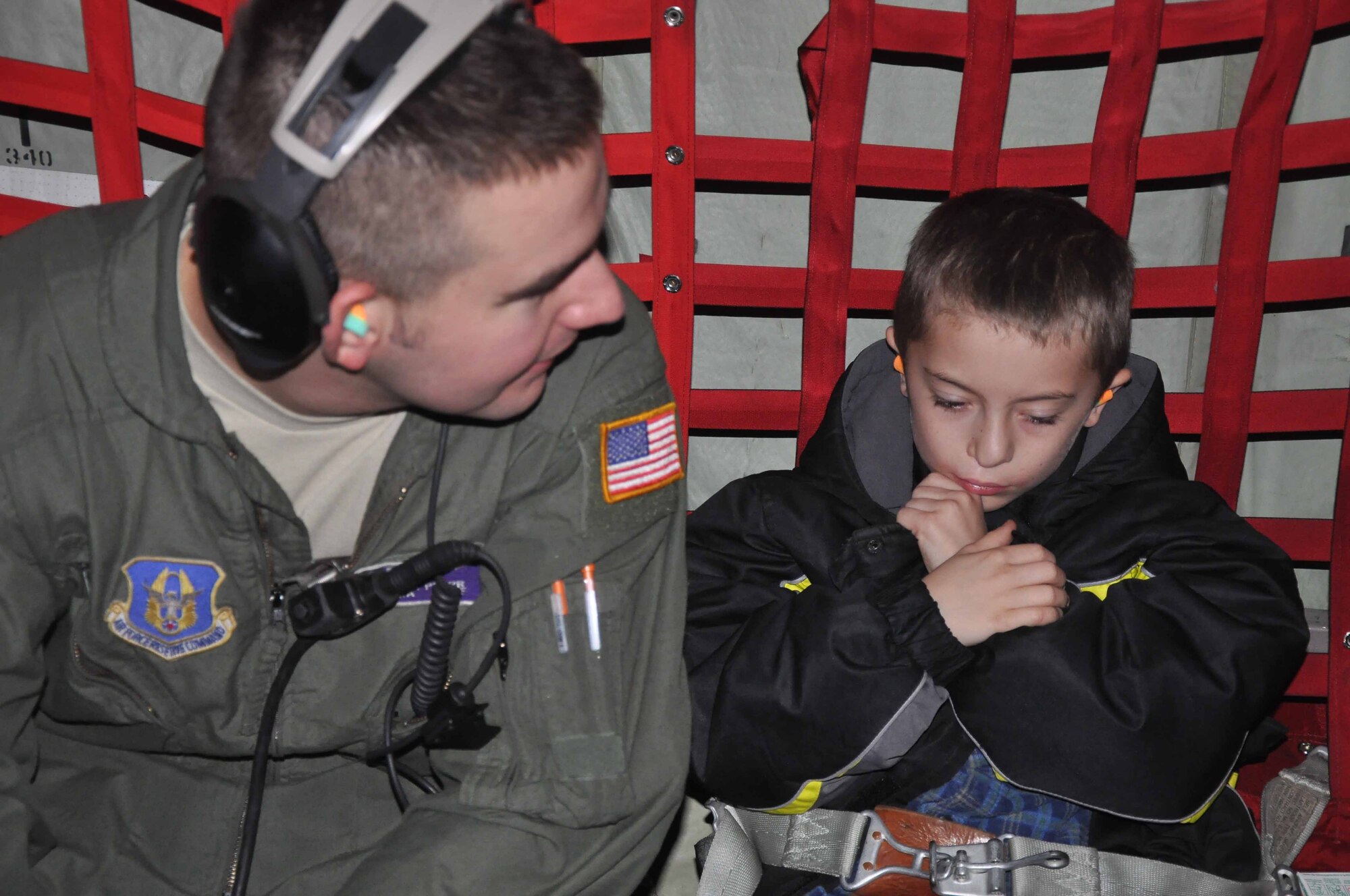 SRA Erik Pfarr talks with special guests during Operation Santa Flight 2010, the 934th Airlift Wing along with volunteers from AT&T and the Army National Guard make it possible for people with special needs to get a trip to meet with Santa (Air Force Photo/Tech. Sgt. Bob Sommer)