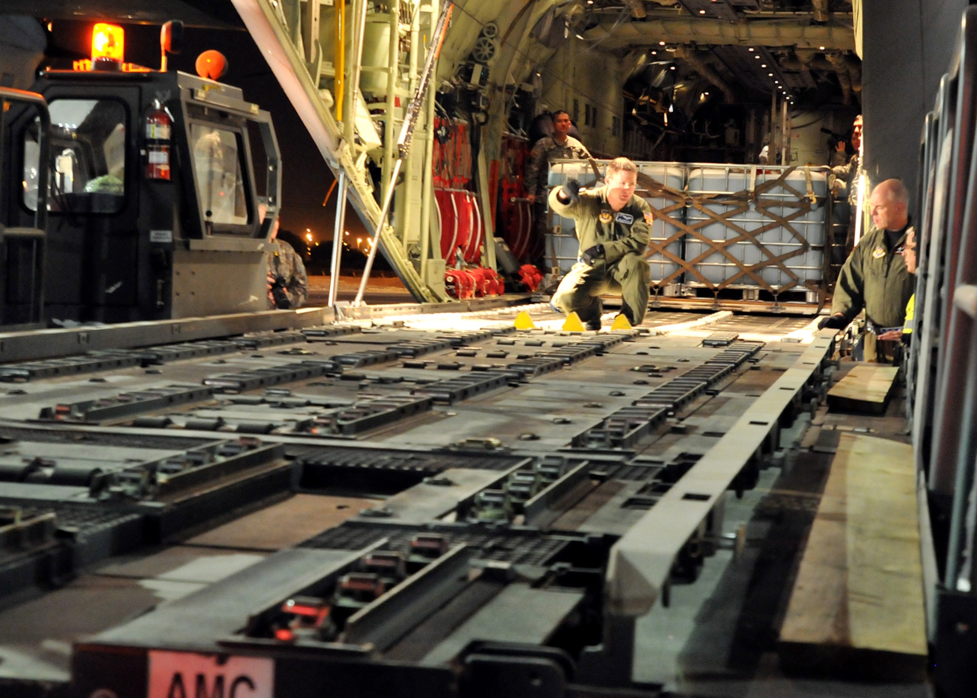 U.S. Airmen unload fire retardant from a C-130-J Super Hercules at the Ben Gurion International Airport, , Israel, Dec. 4.  The fire retardant is part of a joint U.S. Air Forces and U.S. European Command effort to assist the Israeli government in fighting wild fires in their country. (U.S. Air Force photo by Tech. Sgt. Markus M. Maier)
