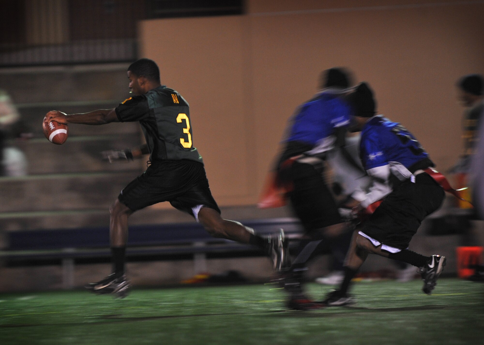 Jamaal Avington, 51st Force Support Squadron, attempts to run past defenders during the base flag football intramural championship Dec. 6 at Osan Air Base, Republic of Korea. The 51st FSS team took home the trophy with a winning score of 26-14 against the 51st Aircraft Maintenance Squadron. (U.S. Air Force photo/Senior Airman Evelyn Chavez)