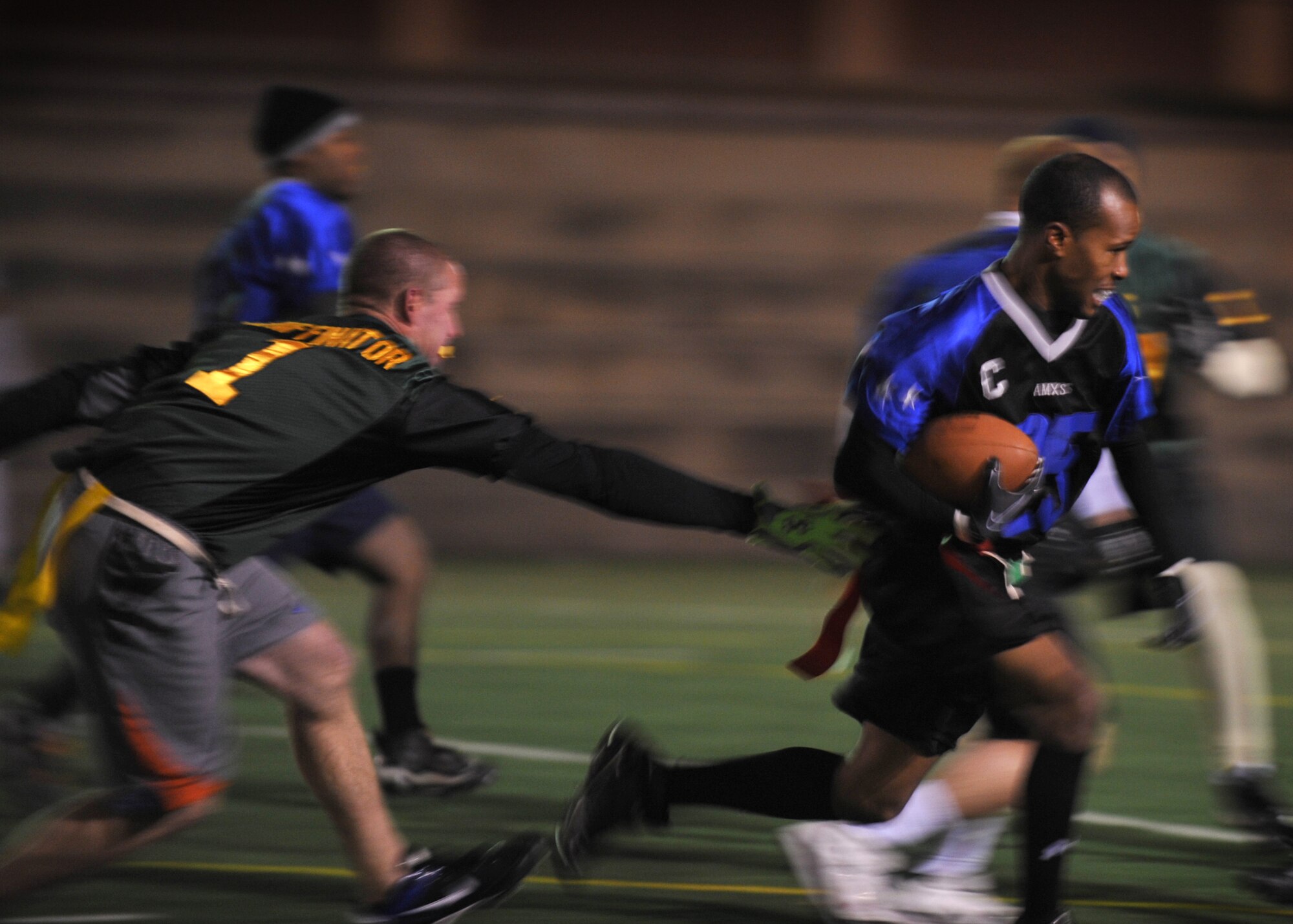 David Bridges, 51st Aircraft Maintenance Squadron, runs past a defender during the base flag football intramural championship Dec. 6 at Osan Air Base, Republic of Korea. The 51st Force Support Squadron took home the trophy with a winning score of 26-14 against the 51st AMXS team. (U.S. Air Force photo/Senior Airman Evelyn Chavez)