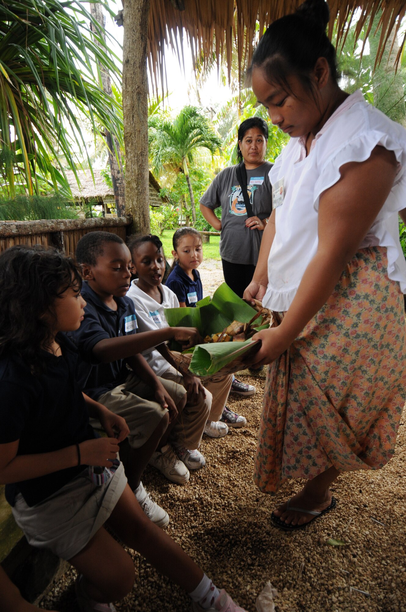 Andersen Elementary 2nd graders sample rice from a katupat during a recent field trip to Gef Pa'go Chamorro Cultural Village in Inarajan Bay.  A katupat is a diamond-shaped container woven of coconut fronds that is used to cook rice. (U.S. Air Force photo/Master Sgt. Carrie Hinson)

