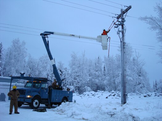 Air Force Civil Engineers working with high voltage power lines during a power outage.  (File photo by Jimmie Denton, 773rd Civil Engineer Squadron)