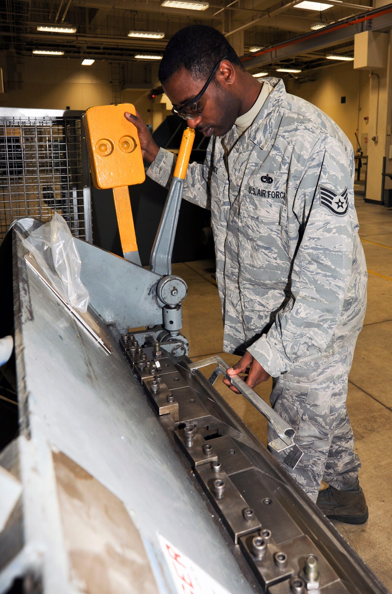 U.S. Air Force Staff Sgt.  Andre McNeil, left, 35th Maintenance Squadron, Aircraft Structural Maintenance, uses a box and pan brake to fabricate metal aircraft components at Misawa Air Base, Japan, Nov. 16, 2010. The fabricated piece is a battery bracket for one of the 35th Fighter Wing?s F-16 Fighting Falcon. (U.S. Air Force photo by Tech. Sgt. Russell McBride/Released)