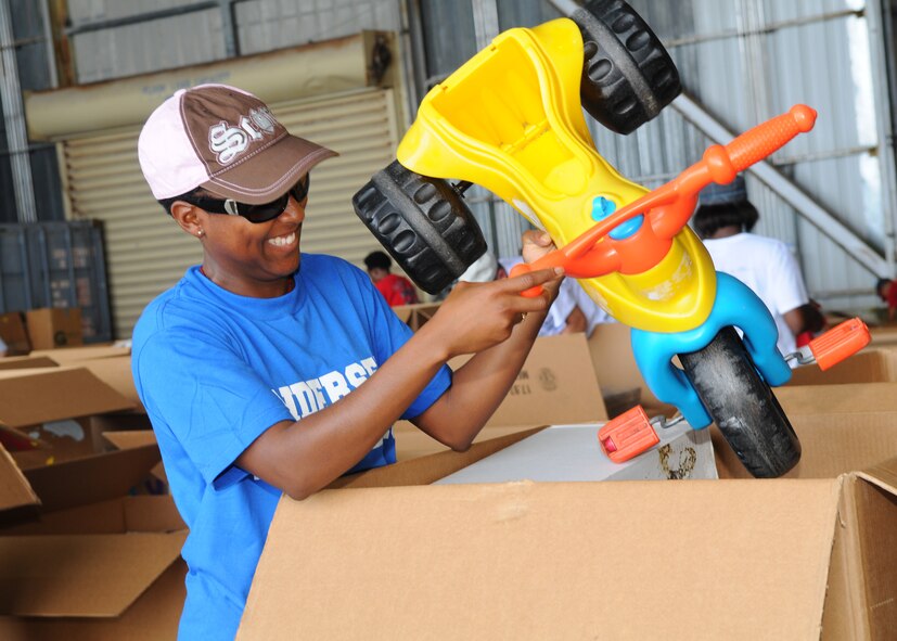 Tech. Sgt. Kaia Pinnock 36th Contracting Squadron places a donated tricycle into one of the boxes during Operation Christmas Drop box build Dec. 4, 2010 at Andersen Air Force Base, Guam.  Throughout the year, volunteers from organizations island-wide donate a variety of items ensuring the people on neighboring islands experience a wonderful holiday. Operation Christmas Drop is a non-profit operation powered by volunteers from Andersen, the 36th Airlift Squadron from Yokota Air Base, Japan and the local community. To date more than 800,000 pounds of goods have been dropped throughout the Marianas, Carolines, Commonwealth of the Northern Marianas Islands and the Federal States of Micronesia Islands.