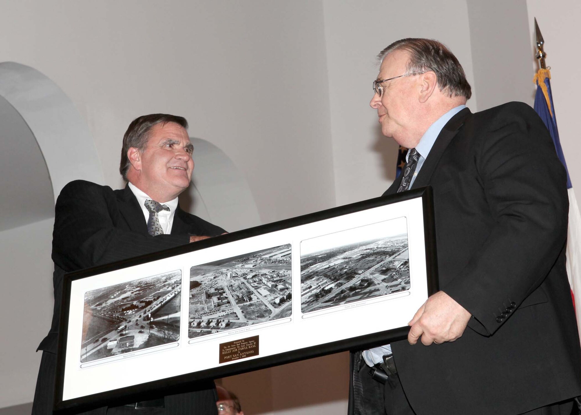 AFRPA Director Robert Moore presents Port San Antonio President & CEO Bruce Miller with historical photos of former Kelly AFB to commemorate the final property transfer.
