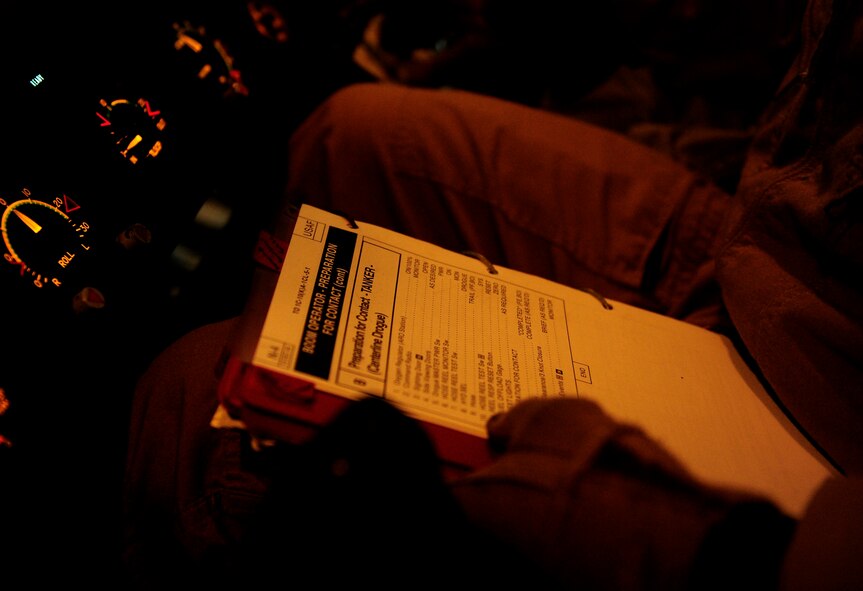 Staff Sgt. Erin Keogh, a KC-10 Extender aircraft loadmaster assigned to the 908th Expeditionary Air Refueling Squadron, holds training manuals in his lap during an aerial refueling mission over an undisclosed location in Southwest Asia in support of Operation Enduring Freedom on Nov. 25, 2010. (U.S. Air Force Photo/Staff Sgt. Andy M. Kin)