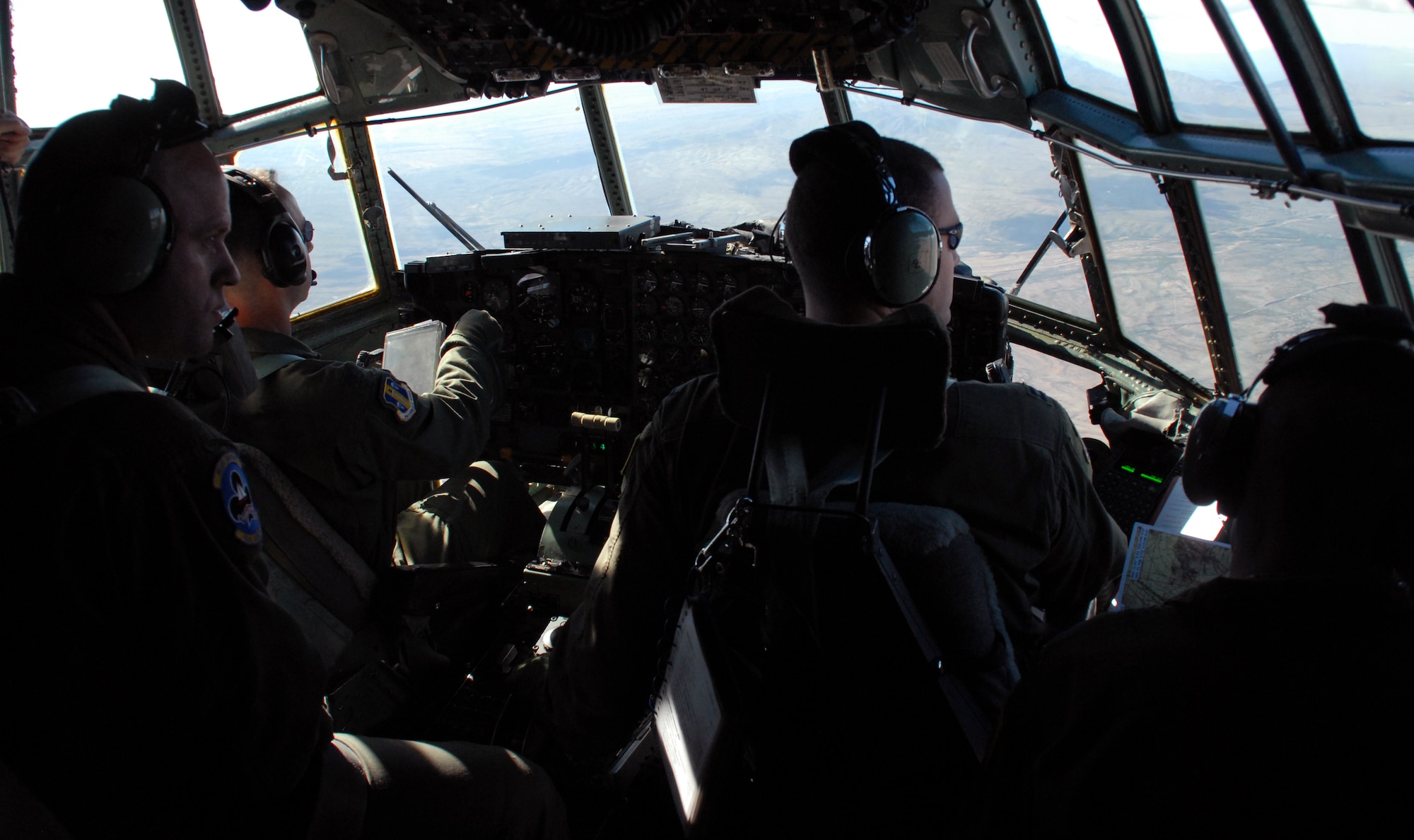 (Left to right) Tech. Sgt. Ken Williams, 62nd Airlift Squadron instructor flight engineer; Col. Mark Czelusta, 314th Airlift Wing commander and the flight's aircraft commander; Capt. Greg Steenberge, 314th AW assistant executive officer and the flight's copilot; and Capt. Jim Sinclair, 62nd AS instructor-navigator, fly over mountainous terrain on the final flight of C-130E aircraft 62-1788, from Little Rock Air Force Base, Ark., to Davis-Monthan Air Force Base's 309th Aerospace Maintenance and Regeneration Group in Arizona Nov. 29, 2010.  The aircraft was retired as part of a strategic Air Force effort to modernize its C-130 fleet with C-130J and C-130H AMP aircraft to meet the needs of today's warfighters in a more efficient, cost-effective way. (U.S. Air Force photo by Capt. Joe Knable)