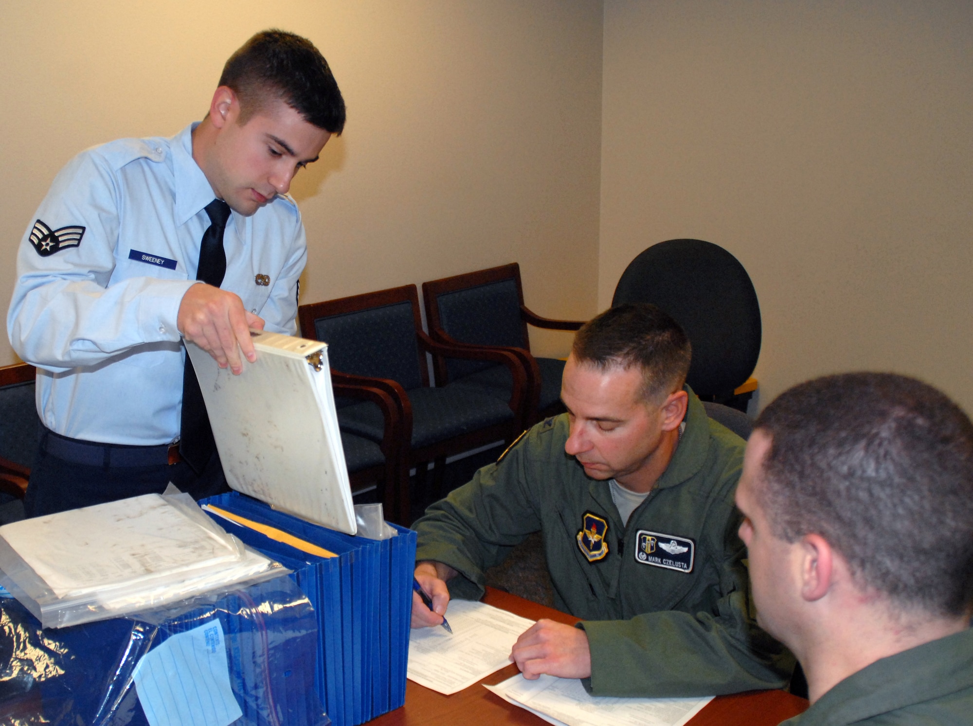 Senior Airman Brian Sweeny of the 314th Maintenance Operations Squadron (left), reviews paperwork with Col. Mark Czelusta, 314th Airlift Wing commander (center), in preparation of Little Rock Air Force Base C-130E aircraft 62-1788 final flight, Davis-Monthan Air Force Base's 309th Aerospace Maintenance and Regeneration Group in Arizona Nov. 29, 2010.  Aircraft 62-1788 was retired as part of a strategic Air Force effort to modernize its C-130 fleet with C-130J and C-130H AMP aircraft to meet the needs of today's warfighters in a more efficient, cost-effective way. (U.S. Air Force photo by Capt. Joe Knable)