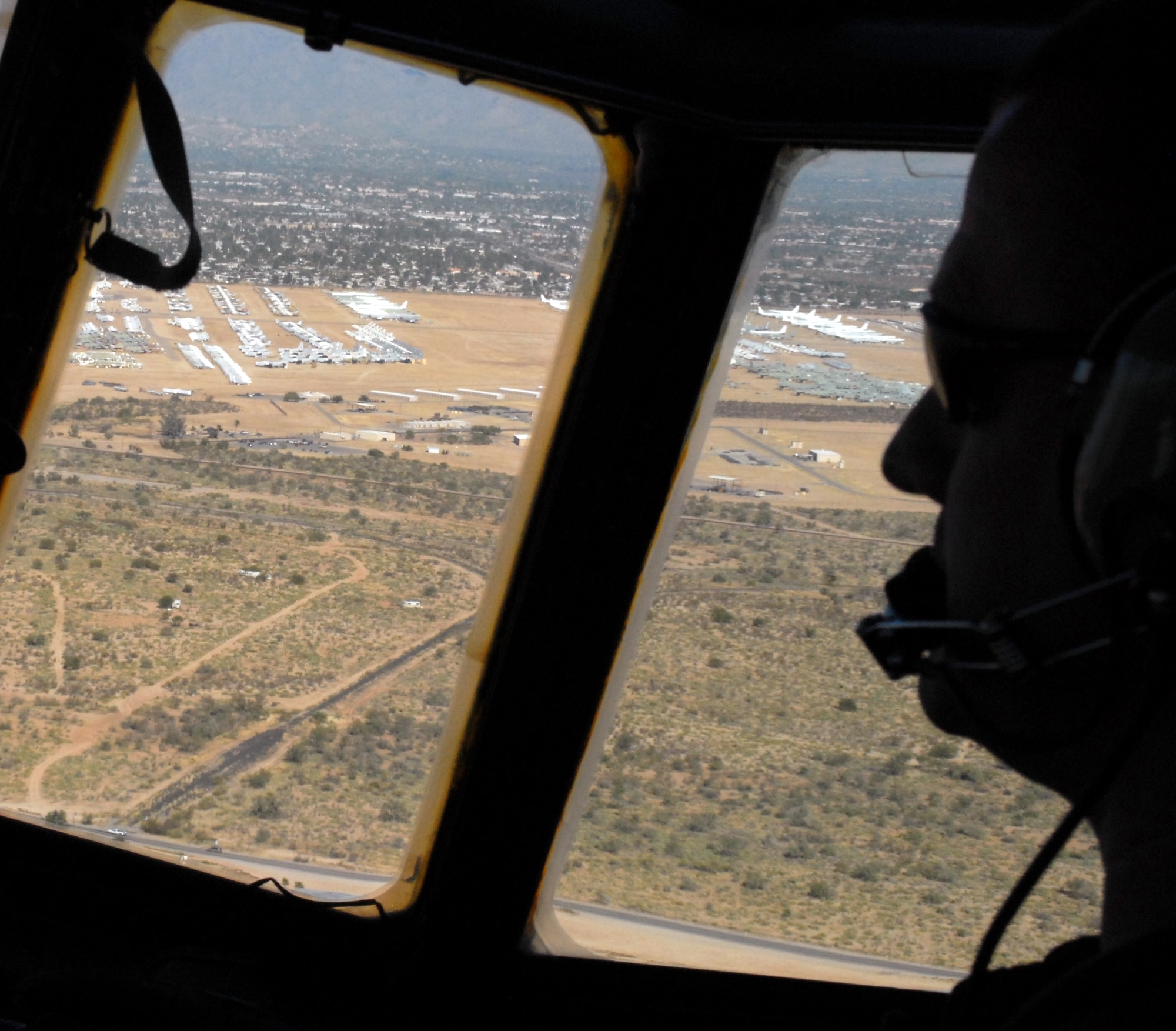 Little Rock Air Force Base C-130E aircraft 62-1788 makes its final descent into Davis-Monthan Air Force Base's 309th Aerospace Maintenance and Regeneration Group in Arizona Nov. 29, 2010, to be retired. Built in 1962, the aircraft's storied history includes supporting major operations in Vietnam from 1667-1973, such as the Tet Offensive. Aircraft 62-1788 was retired as part of a strategic Air Force effort to modernize its C-130 fleet with C-130J and C-130H AMP aircraft to meet the needs of today's warfighters in a more efficient, cost-effective way. Silhouetted is Capt. Greg Steenberge, 314th AW assistant executive officer, the copilot for the flight.  (U.S. Air Force photo by Capt. Joe Knable)