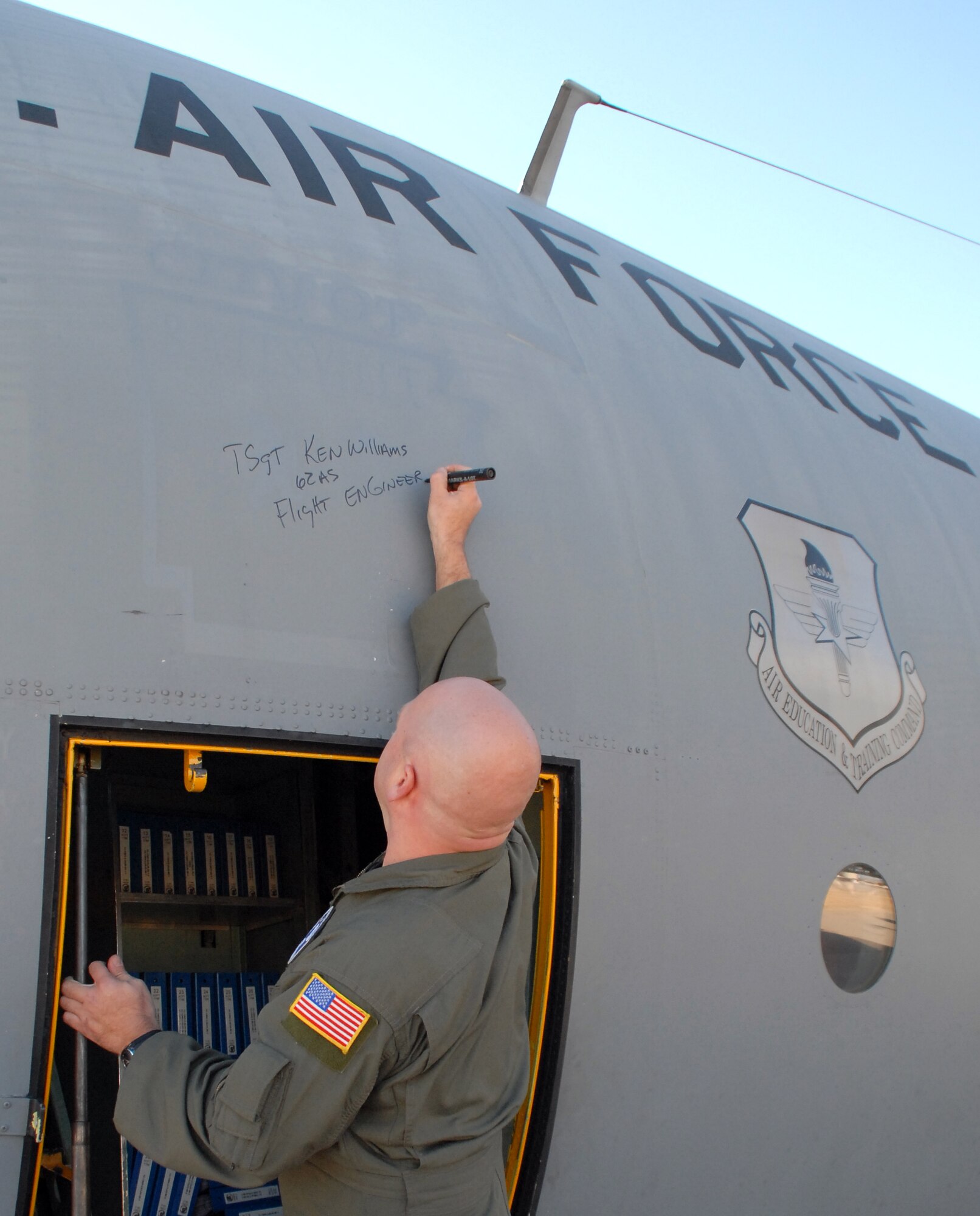 Tech. Sgt. Ken Williams, 62nd Airlift Squadron instructor flight engineer, signs his name on Little Rock Air Force Base C-130E aircraft 62-1788 after it completed its final flight, to Davis-Monthan Air Force Base's 309th Aerospace Maintenance and Regeneration Group in Arizona Nov. 29, 2010. It’s Air Force tradition for the crew who flies an aircraft's final flight to sign the aircraft after landing. Aircraft 62-1788 was retired as part of a strategic Air Force effort to modernize its C-130 fleet with C-130J and C-130H AMP aircraft to meet the needs of today's warfighters in a more efficient, cost-effective way. (U.S. Air Force photo by Capt. Joe Knable)