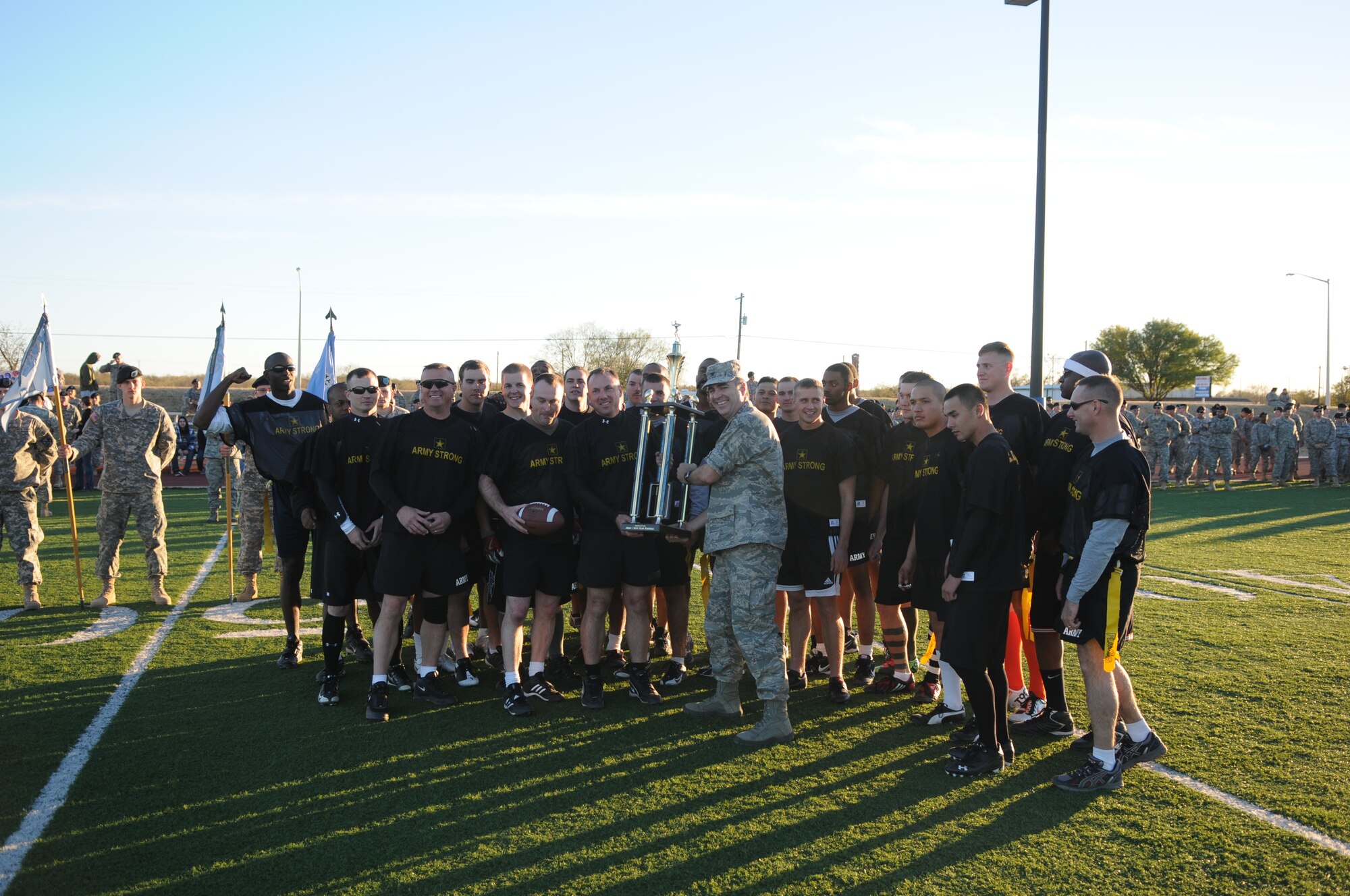 GOODFELLOW AIR FORCE BASE, Texas -- Army Lt. Col. John Bonin, 344th Military Intelligence Battalion Commander, and the 344th MI BN Flag Football team, accept the Army/Navy Flag Football Trophy from Col. Thomas Geary, 17th Training Wing Commander. The Army defeated the Navy in the annual challenge 28-12 Dec. 1. (U.S. Air Force Photo/Airman 1st Class Clayton Lenhardt)