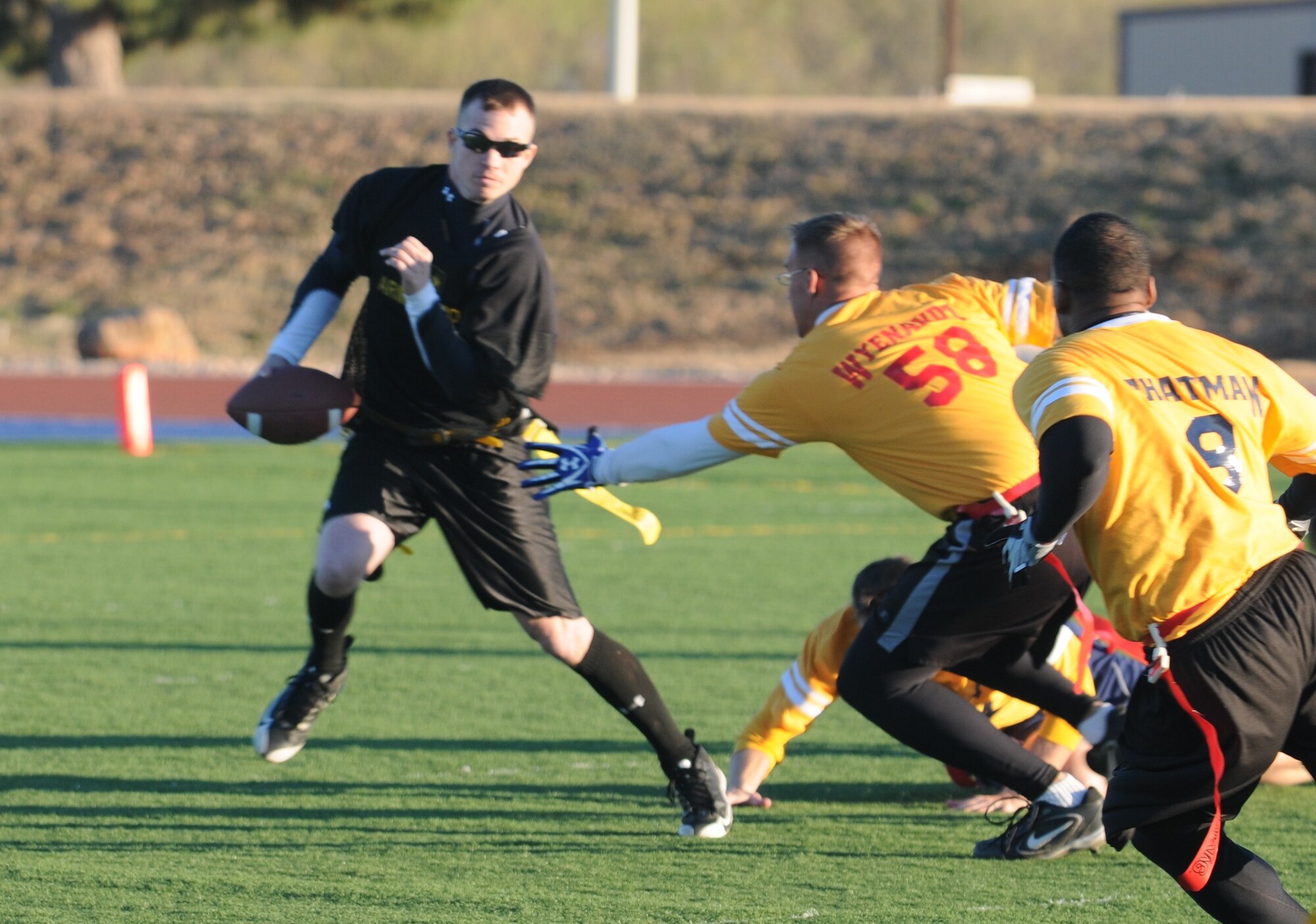 GOODFELLOW AIR FORCE BASE, Texas -- Army quarterback Christopher Guy dodges Navy defender Talan Wyenandt while trying to make a play during the Army/Navy Flag Football Game Dec. 1. Army took the championship: 28-12.  (U.S. Air Force Photo/Airman 1st Class Clayton Lenhardt)