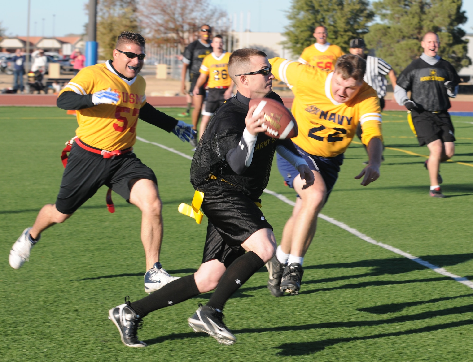 GOODFELLOW AIR FORCE BASE, Texas -- Army quarterback Christopher Guy (middle) tries to get away from Navy team defenders Pedro Rivera (back) and Brian Cobbler (front) for a pass close during the Army/Navy Flag Football Game Dec. 1.  The Army defeated the Navy during the annual challenge: 28-12.  (U.S. Air Force Photo/Airman 1st Class Clayton Lenhardt)