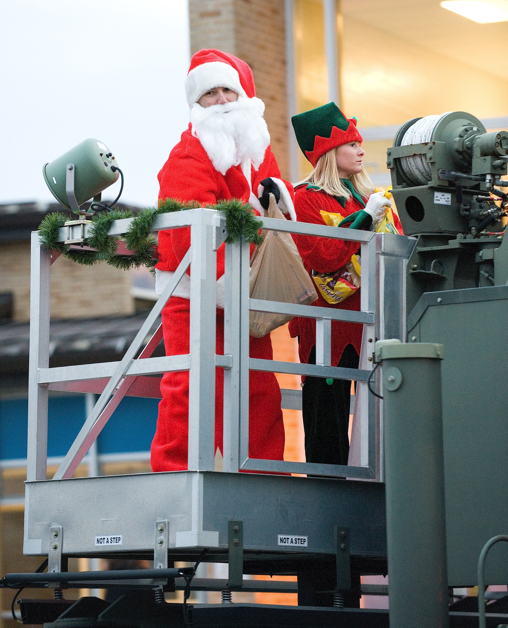 Santa and one of his elves throw candy to children lining the parade grounds during the Dover AFB holiday parade Dec. 2, 2010. (U.S. Air Force photo by Jason Minto/Released)