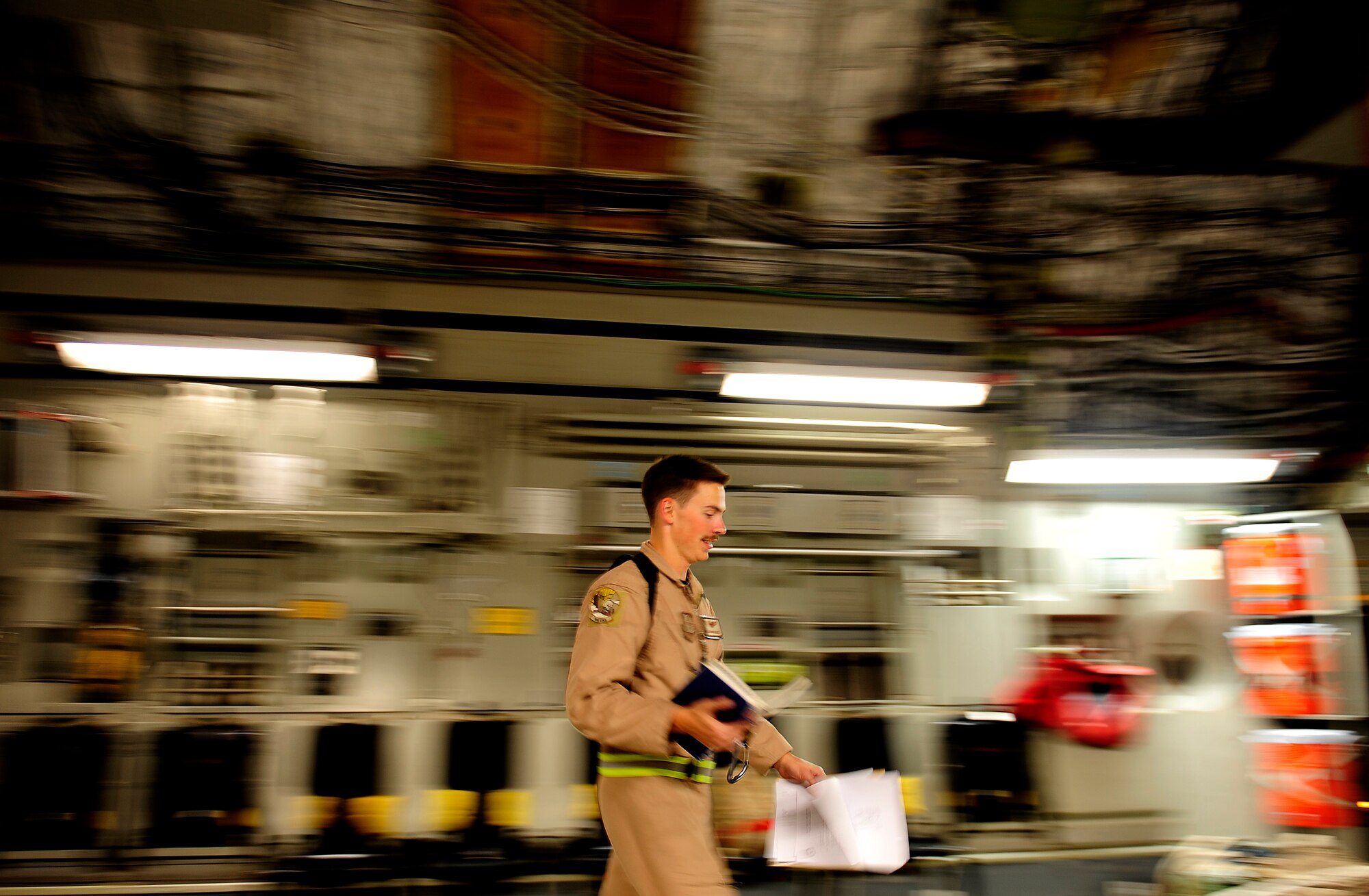 Airman 1st Class David Schmitz, a C-17 Globemaster III aircraft loadmaster assigned to the 816th Expeditionary Airlift Squadron at a non-disclosed base in Southwest Asia, walks back to his station after completing paperwork for a Marine Corps M1A1 Abrams tank being brought to Afghanistan on Nov. 28, 2010. (U.S. Air Force Photo/Staff Sgt. Andy M. Kin)