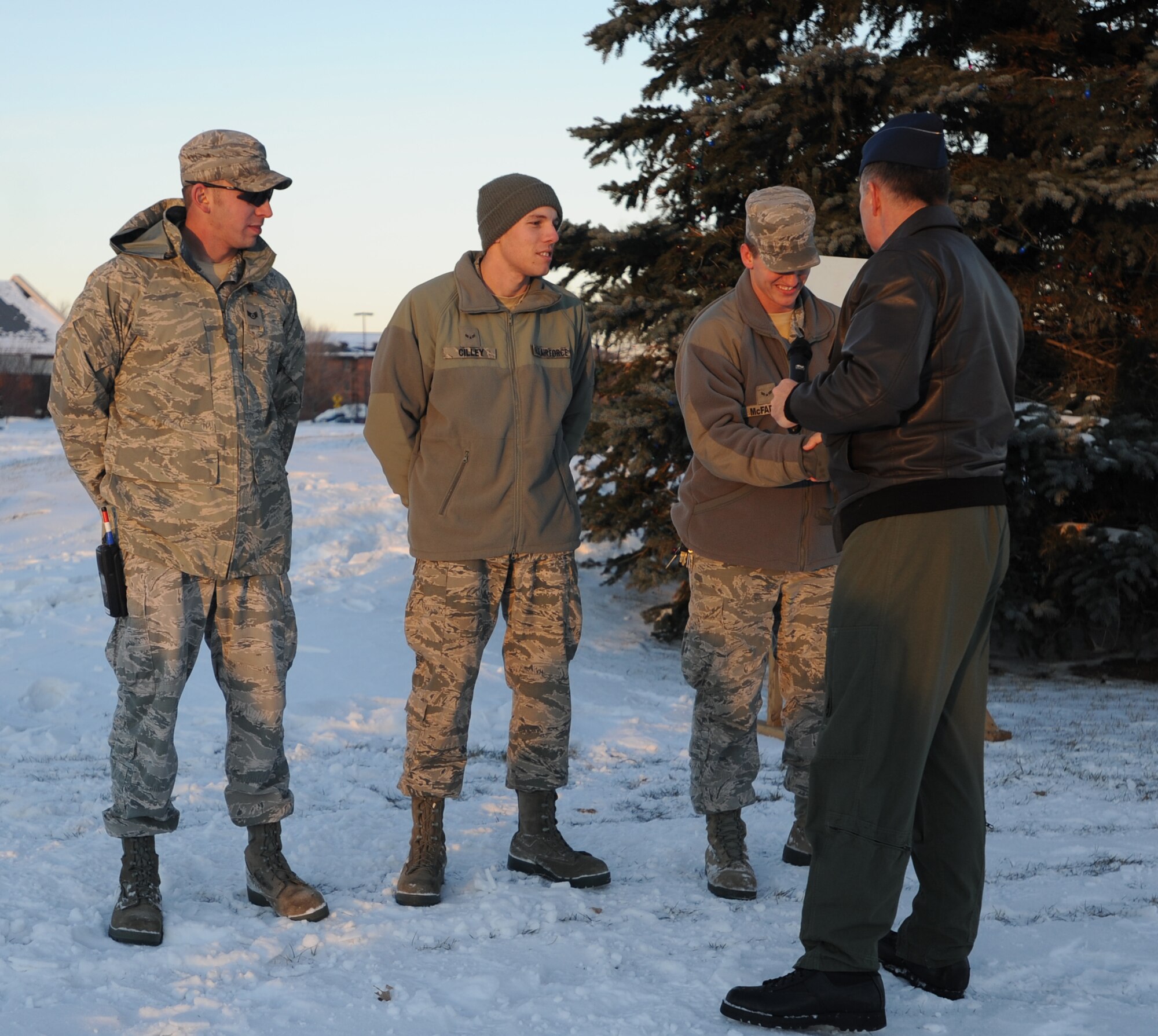 Col. Don Shaffer, 319th Air Refueling Wing commander, congratulates and shakes the hands of Airmen assigned to Grand Forks Air Force Base during the annual holiday tree lighting ceremony Dec. 1 outside of the base fitness center. (U.S. Air Force photo by Staff Sgt. Suellyn Nuckolls)