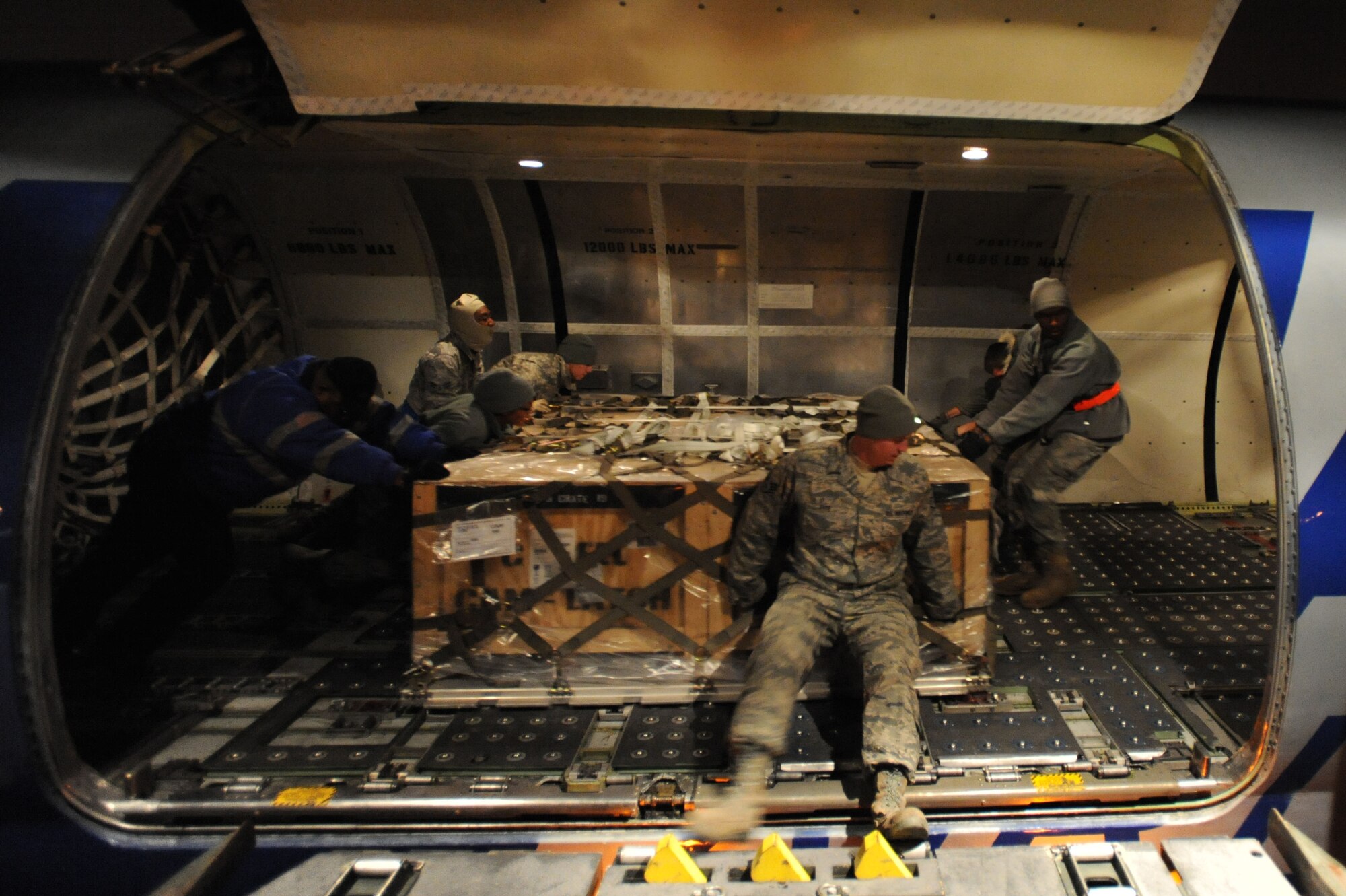 WHITEMAN AIR FORCE BASE, Mo. - Airmen from the 509th Logistics Readiness Squadron load pallets of Los Angeles class submarine batteries into position before securing them in the cargo hold on a DC-8 cargo jet, Dec. 4. The batteries were headed to Guam to aid a nuclear powered submarine the USS Frank Cable is tending to.(U.S. Air Force photo by Senior Airman Carlin Leslie)(Released)