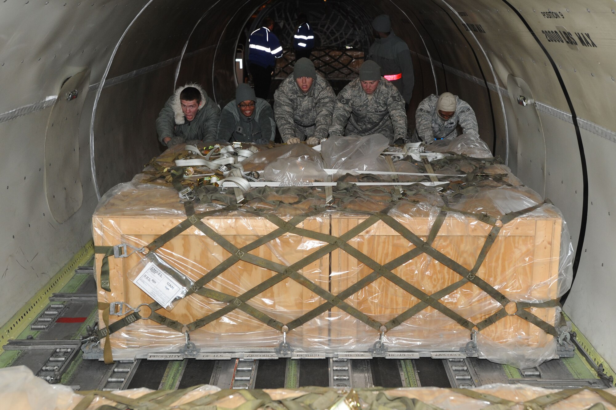WHITEMAN AIR FORCE BASE, Mo. - Airmen from the 509th Logistics Readiness Squadron push pallets of Los Angeles class submarine batteries to the back of a DC-8 cargo jet, Dec. 4. The loading process took nearly two hours after the aircraft landed here. (U.S. Air Force photo by Senior Airman Carlin Leslie)(Released)

