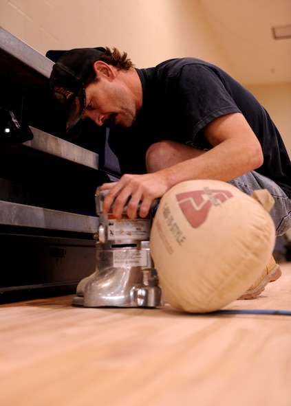 MOODY AIR FORCE BASE, Ga.-- Mike Webb, contracted worker, uses a sand edger to remove the wax from the Freedom I Fitness Center gym floor Dec. 1. The gym floor is being resurfaced for routine maintenance and is required to be replaced every four years. (U.S. Air Force photo/Airman 1st Class Benjamin Wiseman)(RELEASED)