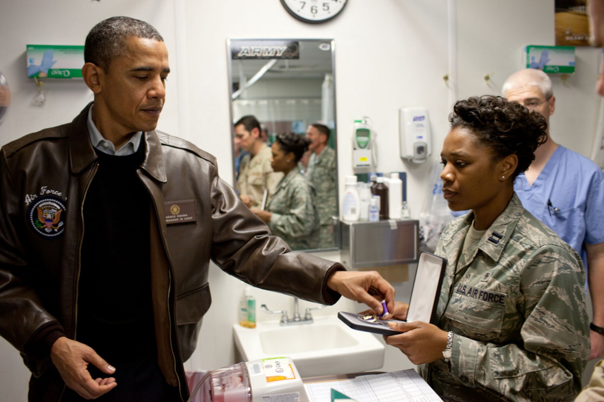 President Barack Obama reaches for a Purple Heart medal which he presented to a wounded soldier Dec. 3, 2010, during a visit to Bagram Airfield, Afghanistan.  (Department of Defense photo)