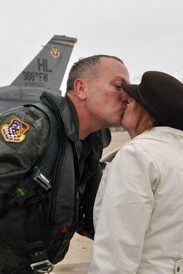 Col. Walter "Buck" Sams, 419th Fighter Wing commander, after being drenched with ice water and champagne, kisses wife, Pam, after his fini flight Dec. 4. (U.S. Air Force photo/Staff Sgt. Heather Skinkle)