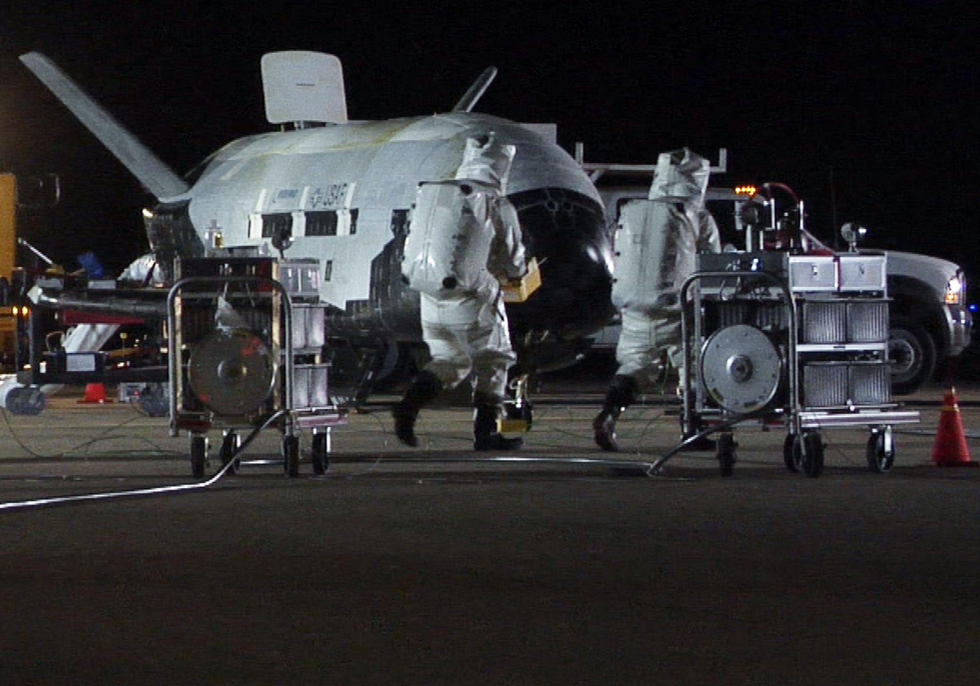 VANDENBERG AIR FORCE BASE, Calif. – Personnel in self-contained atmospheric protective ensemble suits conduct initial checks on the X-37B Orbital Test Vehicle 1 (OTV-1), the U.S. Air Force's first unmanned re-entry spacecraft, after its landing here on Friday, Dec. 3, 2010. The X-37B OTV-1 conducted on-orbit experiments for more than 220 days during its maiden voyage. (U.S. Air Force photo/ Michael Stonecypher)