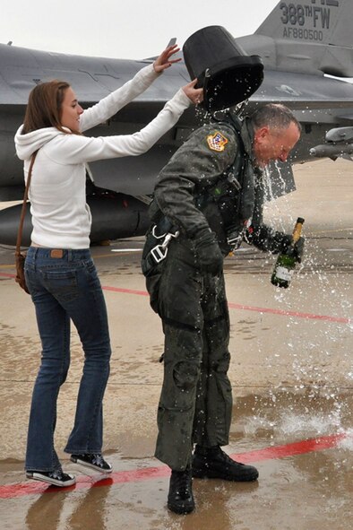 Jessica Sams, daughter of 419th Fighter Wing commander Col. Walter "Buck" Sams, douses her dad with a bucket of ice water after his fini flight Dec. 4. (U.S. Air Force photo/Staff Sgt. Heather Skinkle)