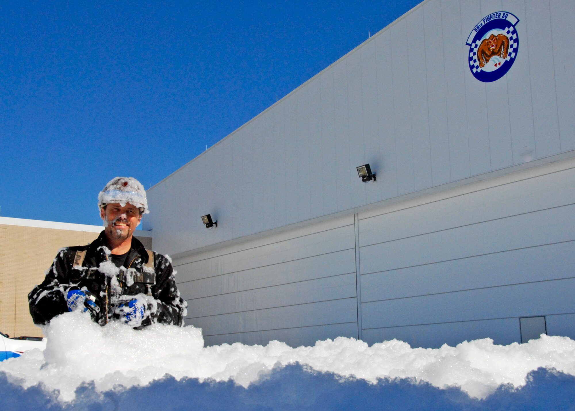 Paul Shutt, contract manager of the Simplex Grinnell Testing Co., moves out of a hangar full of biodegradable foam after testing the new fire suppression system in the newly constructed Air Force F-35 JSF hangar here  Dec. 1. Particularly for fire suppression in areas where petroleum can be present, foam works fastest. It took less than five minutes for the six foam generators to fill the 77,000 square foot hangar with more than three feet of foam. Experts said it could reach the rafters but, for the purpose of completing a series of inspections to certify the new construction ready for use, the test was a success. (U.S. Air Force photo/Sachel Seabrook)

