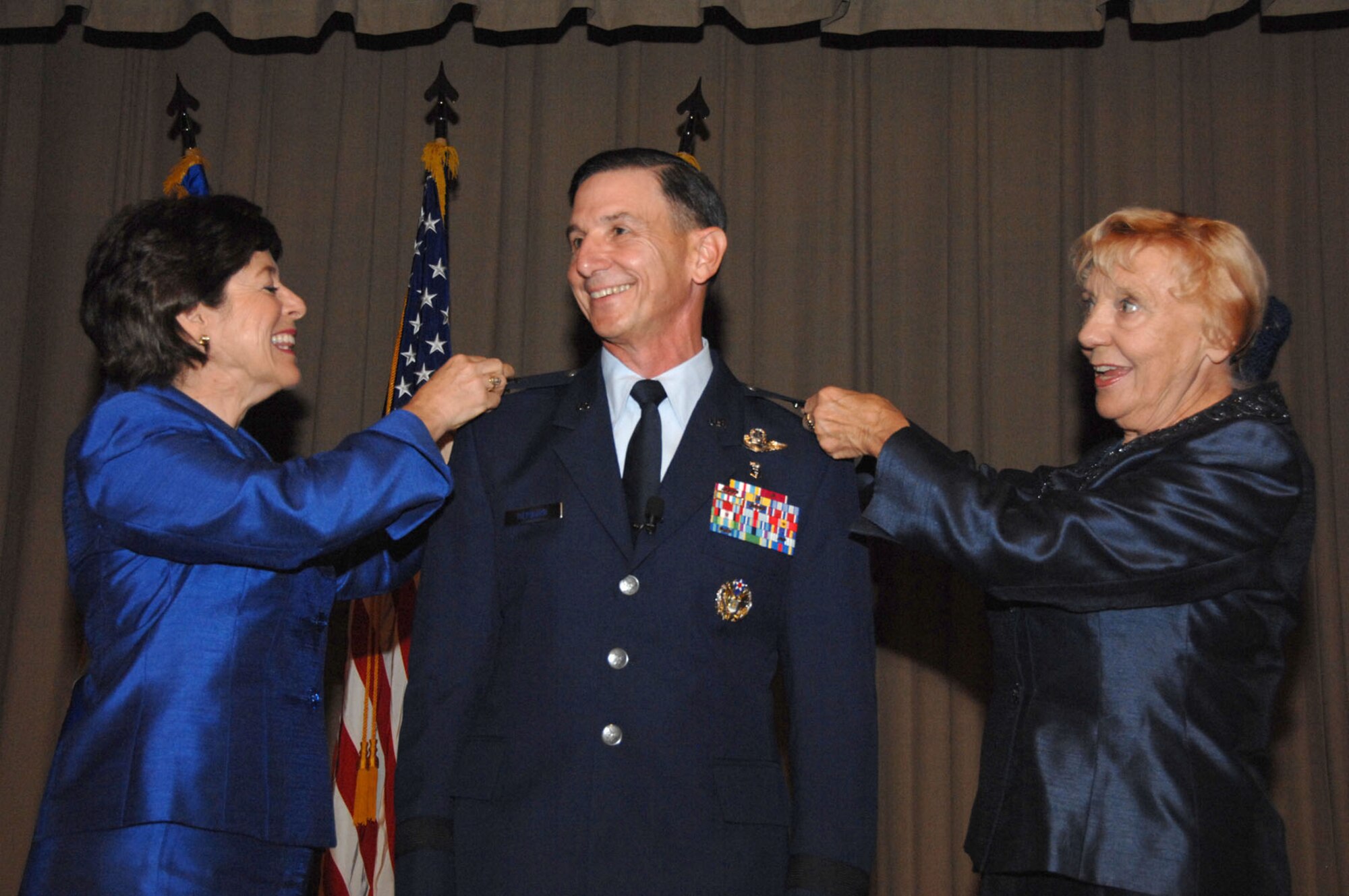 Maj. Gen. Byron Hepburn?s wife, Debby (left), and mother, Yolanda, place his new insignias during his promotion ceremony at Wilford Hall Medical Center, Lackland Air Force Base, Texas, Dec. 3.  The ceremony was officiated by Gen. Edward A. Rice Jr., commander of the Air Education and Training Command.  (U.S. Air Force photo by Staff Sgt. Robert Barnett)