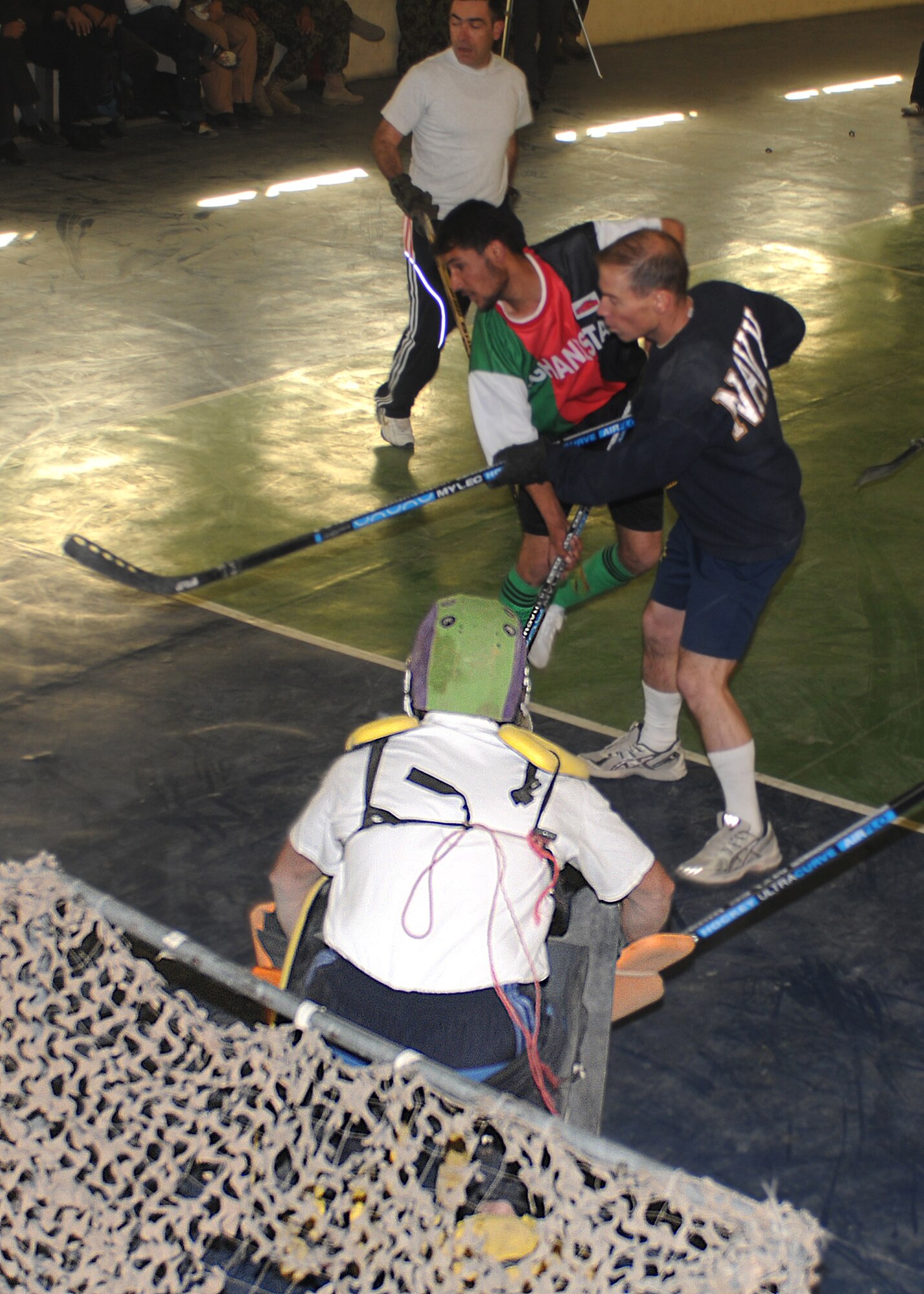 KABUL, Afghanistan - Players tussle in front of the NATO net during an exhibition hockey game between NATO troops and the Nuristan provincial field hockey team at the Afghan Air Force Base gymnasium in Kabul, Afghanistan, Dec. 5. (Photo by MC2 Vladimir Potapenko/RELEASED)