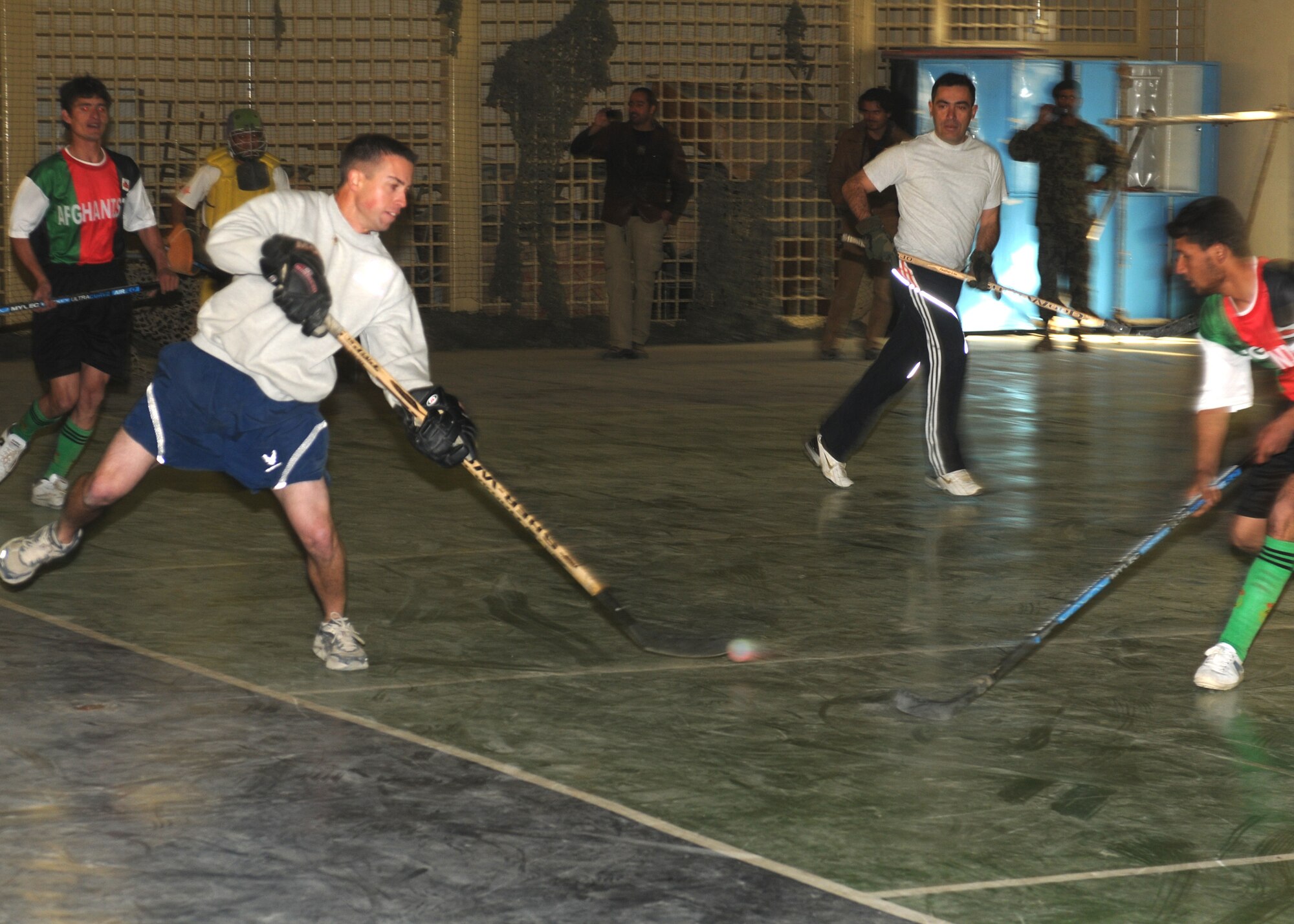 KABUL, Afghanistan - U.S. Air Force Tech. Sgt. Matthew Chouinard, an advisor with the 438th Air Expeditionary Advisory Squadron, shoots the puck during an exhibition hockey game between NATO service members and the Nuristan provincial field hockey team at the Afghan Air Force Base gymnasium in Kabul, Afghanistan, Dec. 5. (Photo by MC2 Vladimir Potapenko/RELEASED)