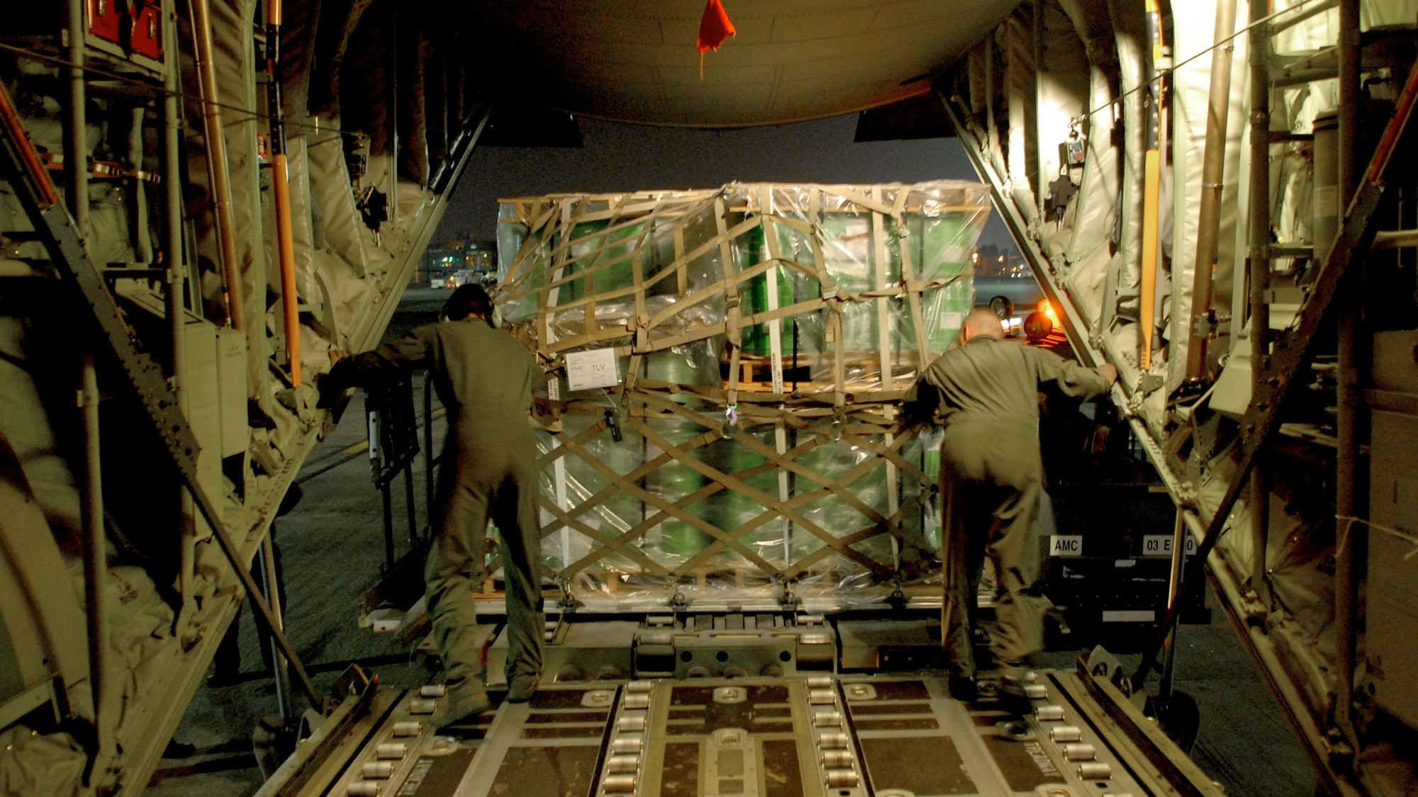TEL AVIV, Israel – Master Sgt. Jason Kunkel and Airman 1st Class Ryan Caves, load masters for the 37th Airlift Squadron based at Ramstein Air Base, Germany, off load approximately 13.5 tons of fire suppression agent from a C-130J aircraft onto an Israeli K-loader Sunday, Dec. 5, 2010, at Tel Aviv International Airport. So far the U.S. has donated 30,000 liters of fire retardant, with plans to deliver 60,000 more over the next three days to aid firefighting efforts in Israel. (U.S. Air Force photo by Capt. John Ross)