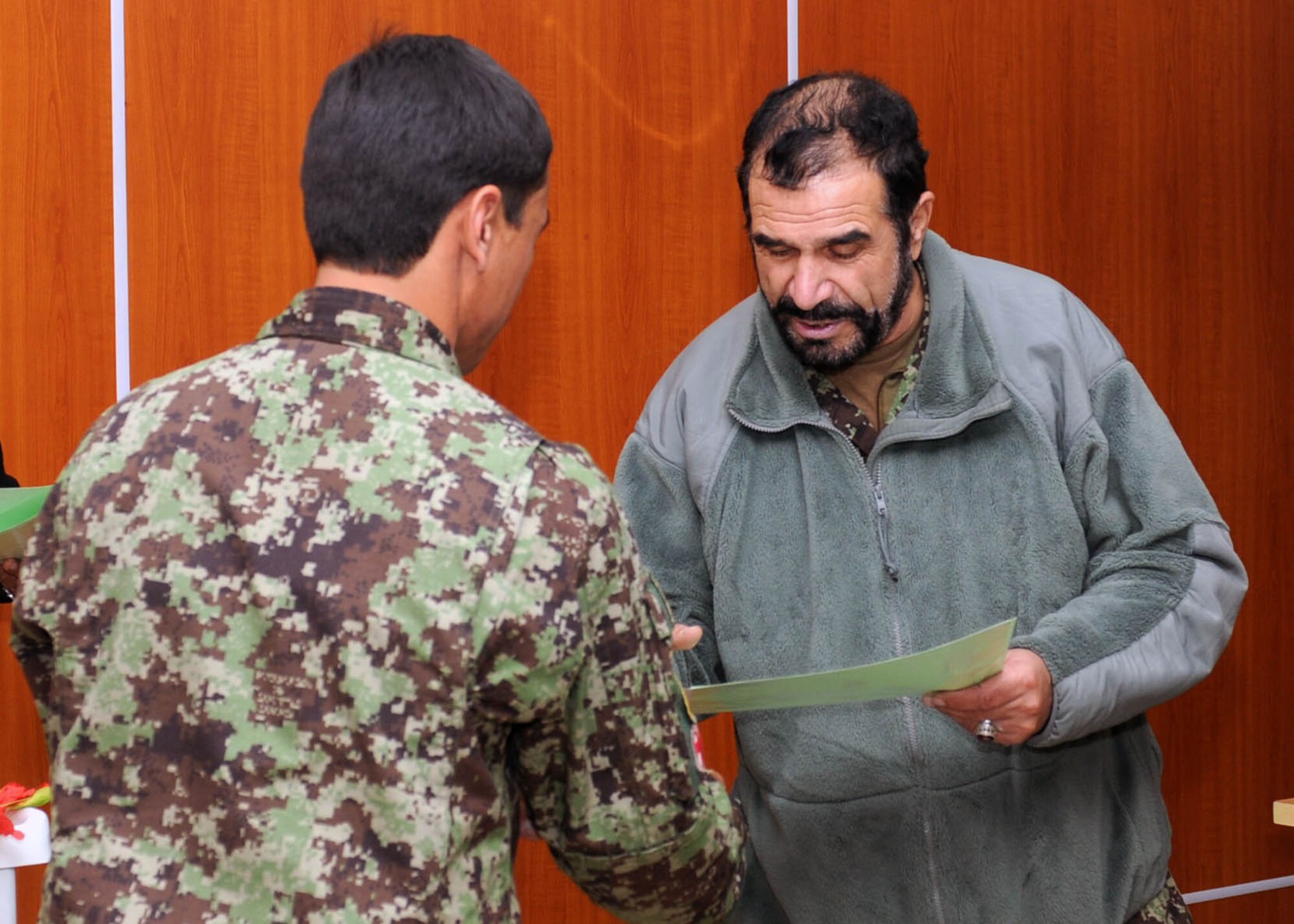 101206-N-6541W-005 KABUL, Afghanistan - Gen. Darwan, Commanding General of the Afghan Air Force presents a certificate to a newly graduated flight medic in the Afghan Air Force at the Afghan Air Force Base on Kabul International Airport, Dec. 6. This is the first medical course to be instructed by an Afghan Air Force flight medic instructor.  (U.S. Navy photo by Mass Communication Specialist 3rd Class Jared Walker/ RELEASED).