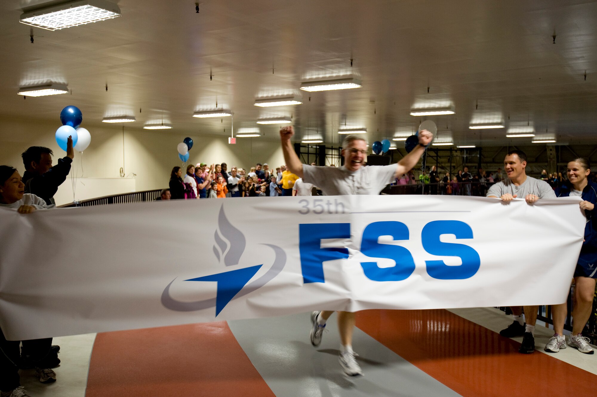 U.S. Air Force Col. David Wiegand, 35th Mission Support Group commander, was the first to finish a celebratory lap on the new, elevated track inside the Weasels' Den at Misawa Air Base, Japan, Dec 4, 2010. The elevated indoor track is 200 meters long and coated in a non-slip vinyl surface, and will provide runners room to exercise during inclement weather. (U.S. Air Force photo by Airman James B. Bauer/Released)
