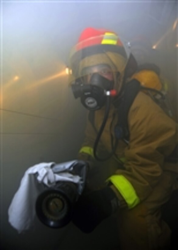U.S. Navy Fireman John Stull makes his way through a smoke-filled compartment during a general quarters drill aboard the aircraft carrier USS George Washington (CVN 73) underway in the Pacific Ocean on Dec. 1, 2010.  The George Washington is participating in Keen Sword 2010, a scheduled joint exercise with the Japan Maritime Self-Defense Force through Dec. 10.  