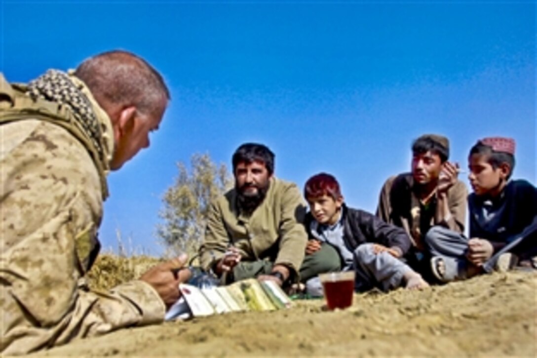 U.S. Marine Corps Chief Warrant Officer 3 Anthony J. Reiter speaks with Afghans near Patrol Base Amir, Afghanistan, Nov. 29, 2010. Reiter, a engineer equipment officer, is assigned to Engineer Company, Combat Logistics Battalion 3, 1st Marine Logistics Group. Fifty Marines with the Engineer Company completed miles of road improvements in Afghanistan's Helmand province.