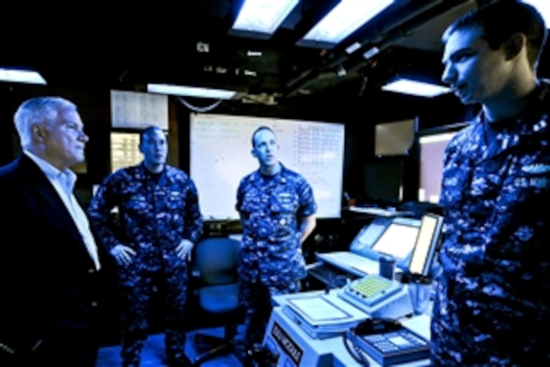 U.S. Defense Secretary Robert M. Gates receives a brief on the Combat Direction Center while aboard the USS Abraham Lincoln Carrier Strike Group Nine in the Arabian Sea, Dec. 6, 2010.