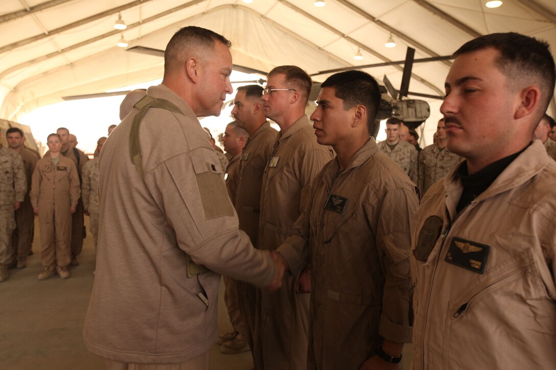 Brig. Gen. Andrew W. O'Donnell Jr., the 3rd Marine Aircraft Wing (Forward) commanding general, shakes hands with Cpl. Oscar Melgar, an aerial observer with Marine Heavy Helicopter Squadron 362, 3rd MAW (Fwd), after awarding him his combat aircrew wings at the flightline aboard Camp Bastion, Afghanistan, Dec. 6.  Melgar and four other HMH-362 Marines received their combat aircrew wings for flight time during a deployment.  It is a prestigious distinguishing device as it is symbolic of Marine aviation’s deep bond and commitment to supporting the infantry and coalition forces in Afghanistan.