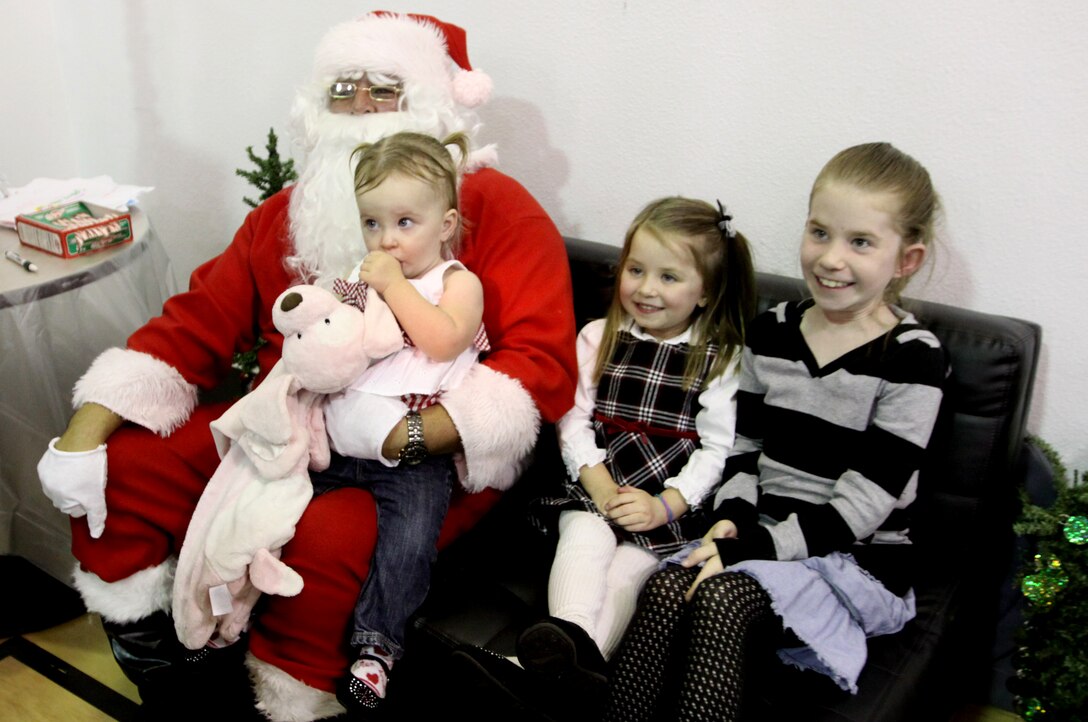 (From right to left)  Hayley, Kendall and Cassidy Hall sit with Santa during Camp Pendleton’s Exceptional Family Member Program annual holiday party at the Abbey Reinke Community Center, Dec. 6. During the event, families were given a free dinner provided by the program and a local community restaurant that included turkey, pies and Italian cuisines.
