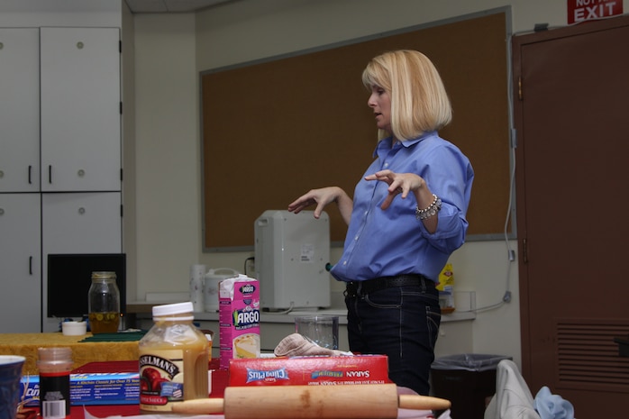 Gina Friedhoff, counselor at Matthew C. Perry Elementary School, explains the objects on the table in front of her as she teaches the Ideas That Cook with Kids class at the M.C. Perry Elementary School here Dec. 7.