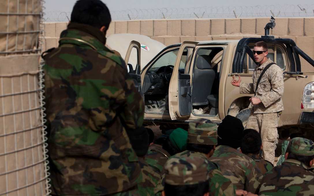 Lance Cpl. Aaron Ellison, an assistant instructor with the Regimental Combat Team 1 Embedded Training Team, gives a vehicle checkpoint class to novice Afghan National Army soldiers at Camp Dwyer, Helmand province, Afghanistan, Dec. 7. Although Marines still provide classroom instruction, ANA instructors from Camp Dwyer’s first ANA instructor course now lead the majority of the practical application exercises. The first wave of ANA instructors from Camp Dwyer graduated from the instructor course here last month.