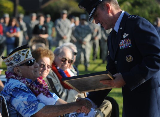 Lt. Gen. Hawk Carlisle presents Phillip Corsello, a former Army Air Corps private, with a  plaque that  thanked him for his service to his country at the 69th anniversary remembrance ceremony on Joint Base Pearl Harbor-Hickam Dec. 7, 2010. General Carlisle is the 13th Air Force commander. (U.S. Air Force Photo/Airman 1st Class Lauren Main)