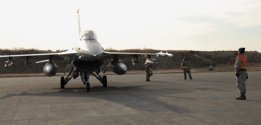 U.S. Air Force Staff Sgt. Yeakel Nikolai, 35th Aircraft Maintenance Squadron weapons load crew chief, right, salutes an F-16 Fighting Falcon pilot as the pilot prepares to taxi to the Komatsu Japan Air Self-Defense Force base runway following a weapons inspection, Dec. 6, 2010. The Airmen are deployed to Komatsu JASDF base to participate in Keen Sword 2011, a regularly scheduled exercise that strengthens Japan-U.S. military interoperability and meets mutual defense objectives. (U.S. Air Force photo by 1st Lt. Cammie Quinn)