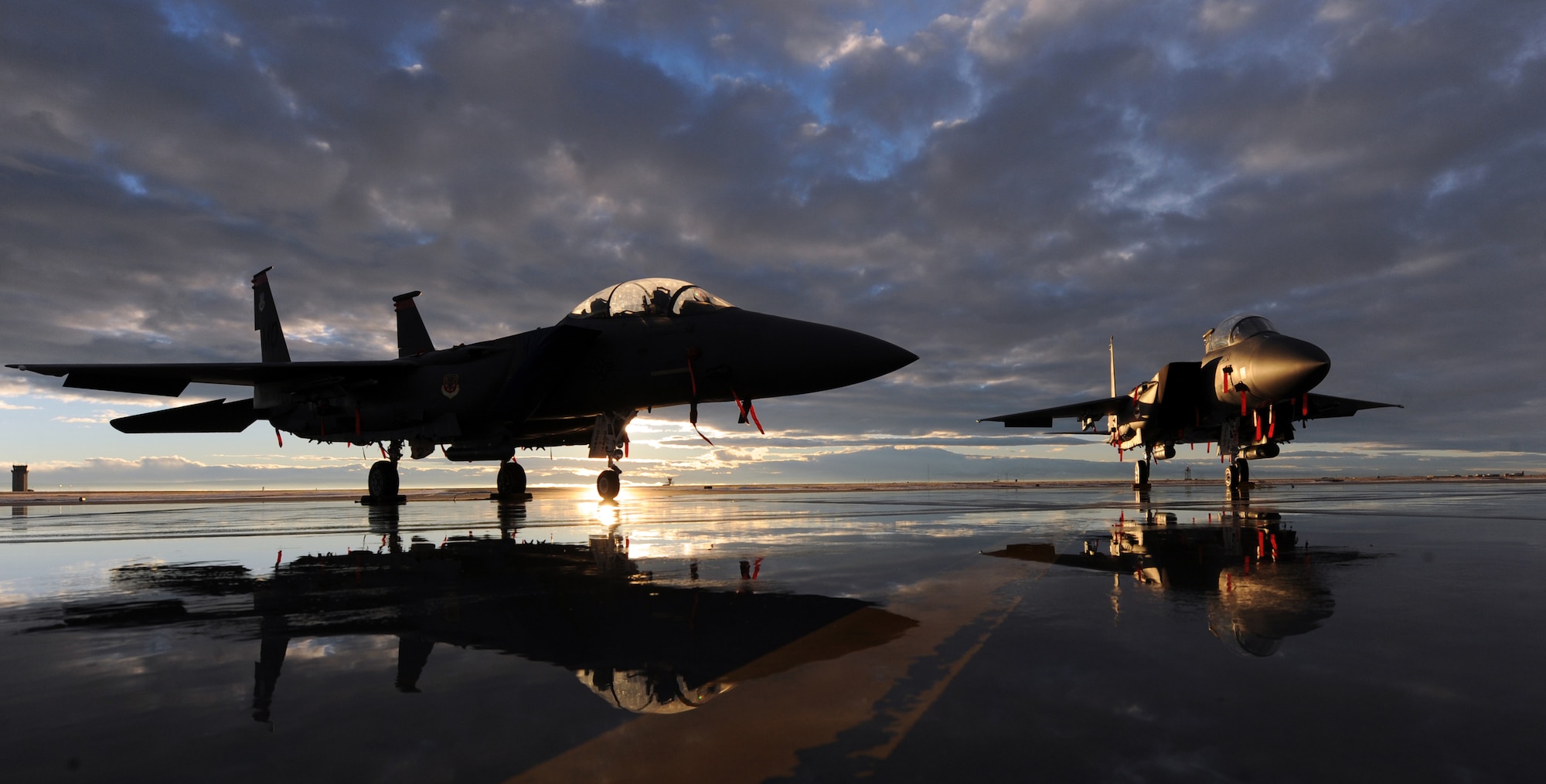 MOUNTAIN HOME AIR FORCE BASE, Idaho – Two F-15E Strike Eagles assigned to the 391st and 389th Fighter Squadrons sit on the flightline during sunset, Dec. 6. The F-15E Strike Eagle is a dual-role fighter designed to perform air-to-air and air-to-ground missions. An array of avionics and electronics systems gives the F-15E the capability to fight at low altitude, day or night, and in all weather. (U.S. Air Force photo by Senior Airman Debbie Lockhart)