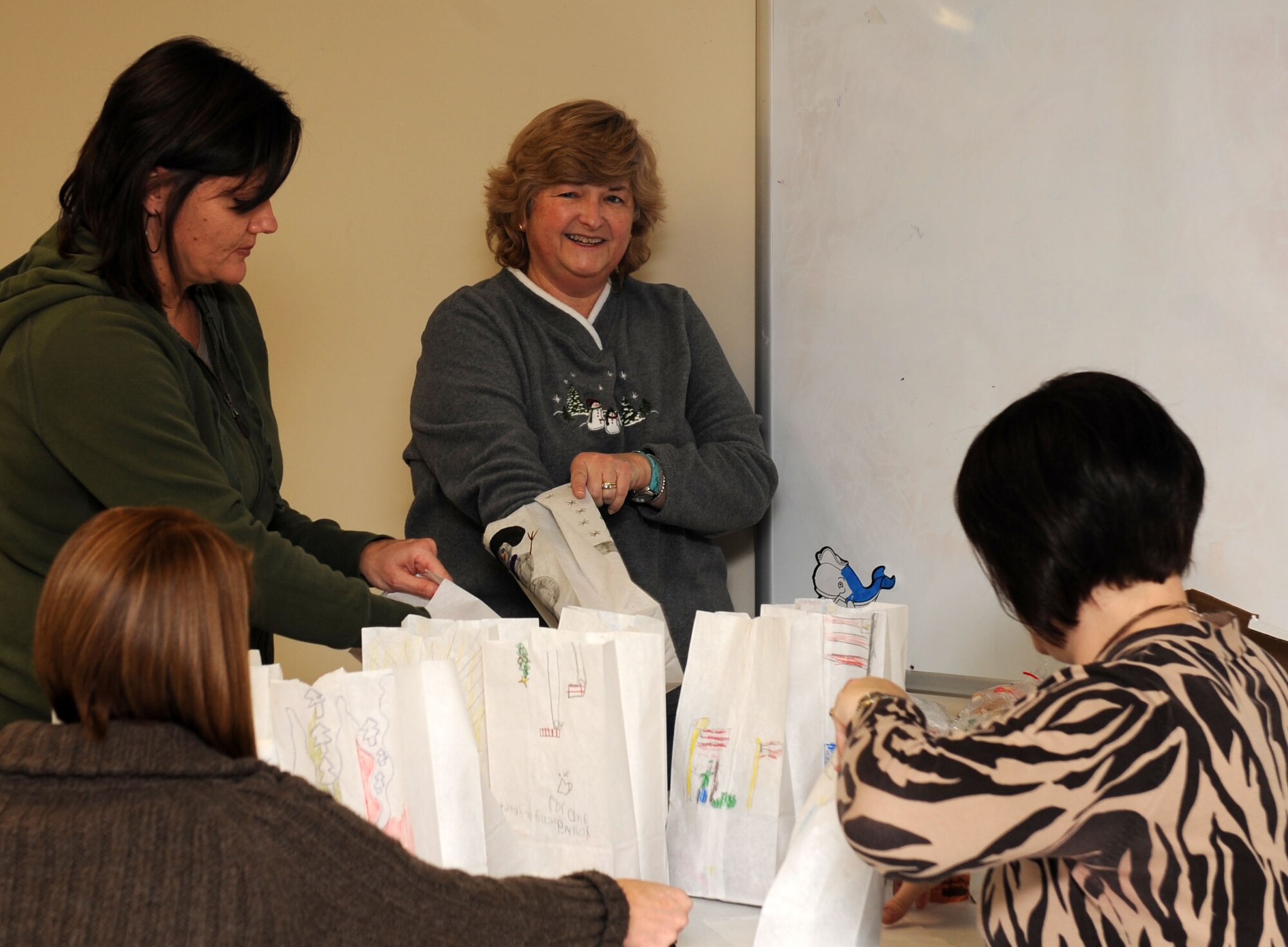 SCOTT AIR FORCE BASE Ill. – Women from the Officer Spouses Club fill bags with cookies to be donated to dorm residents Dec. 7, 2010.  With the help of base volunteers and the local community, the OSC collected over 12,000 cookies to be hand delivered to Airmen in the dorms and around base. (U.S. Air Force photo/ Airman 1st Class Divine Cox) 