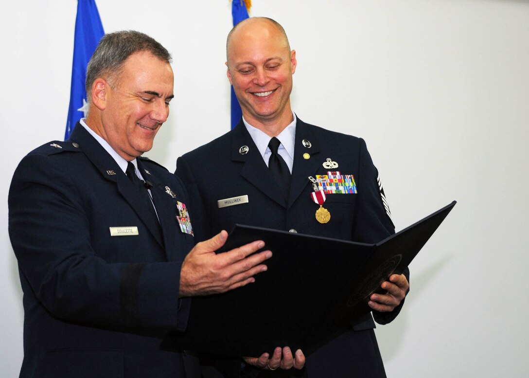 Brig. Gen. John Doucette, 36th Wing commander, and Chief Master Sgt. Allen Mullinex, former 36th Wing command chief, read a certificate during Chief Mullinex's retirement ceremony Dec. 3 at the Sunrise Conference Center. After an illustrious 25-year career, Chief Mullinex looks forward to completing his master's degree in business, snorkeling and learning how to dive. The outgoing command chief is being replaced by Chief Master Sgt. Margarita Overton, from the 78th Mission Support Group at Robins Air Force Base, Ga. (U.S. Air Force photo/ Senior Airman Nichelle Anderson)