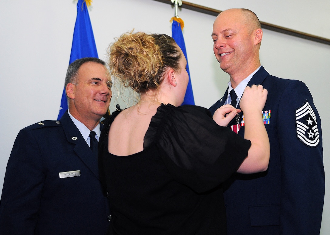 Alicia Mullinex attaches a retirement pin to her father, former Command Chief Master Sgt. Allen Mullinex, during his retirement ceremony Dec. 3 at the Sunrise Conference Center. Chief Mullinex, a native of Grand Lake, Colo.,  acted as the principal advisor to the 36th Wing Commander on matters affecting the utilization, health, morale and welfare of more than 8,500 military and civilian personnel during his tour here. The outgoing command chief is being replaced by Chief Master Sgt. Margarita Overton, from the 78th Mission Support Group at Robins Air Force Base, Ga. (U.S. Air Force photo/ Senior Airman Nichelle Anderson)