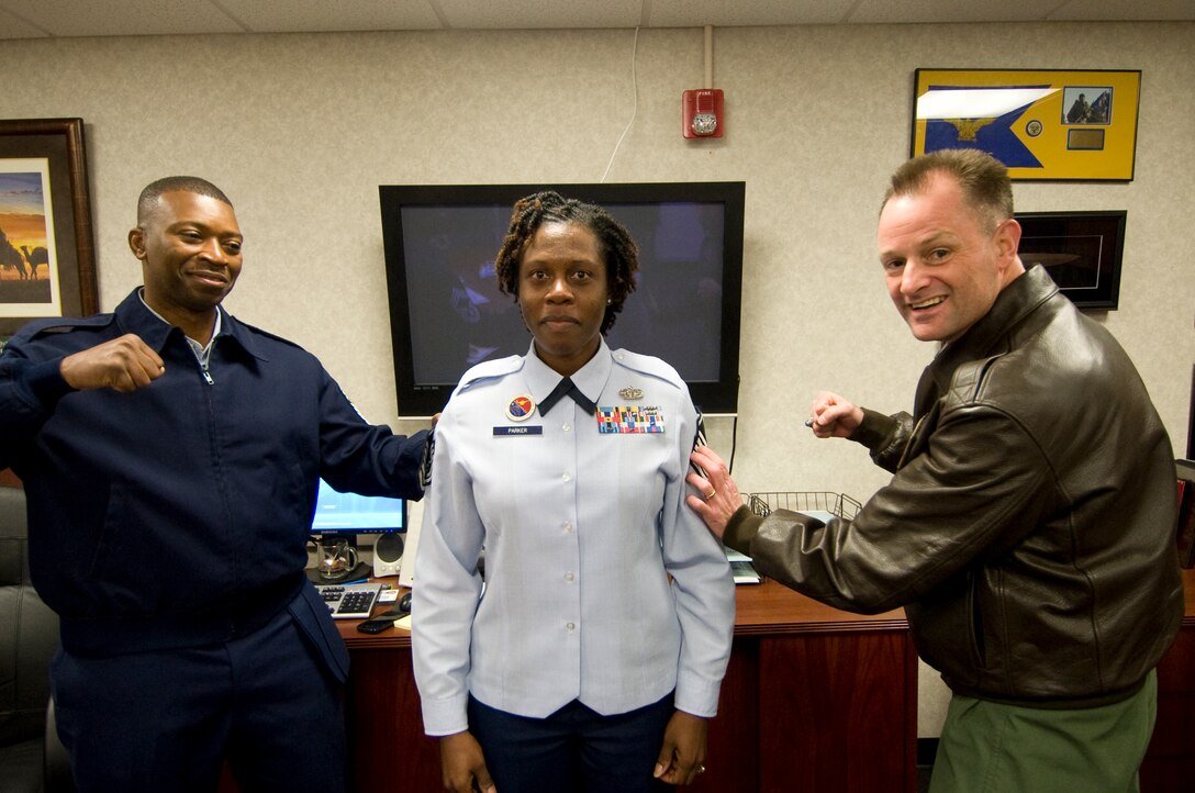 ANDREWS AIR FORCE BASE, Md. -– Technical Sgt. Kenyel Parker, 11th Force Support Squadron Airmen Leadership School instructor, receives a ceremonial punch from Chief Master Sgt. Anthony Woods, 11th Mission Support Group superintendent, left, and Col. Ken Rizer, 11th Wing/Joint Base Andrews commander, during an impromptu step promotion, elevating her to the rank of master sergeant Dec. 6 (U.S. Air Force photo/Bobby Jones) 